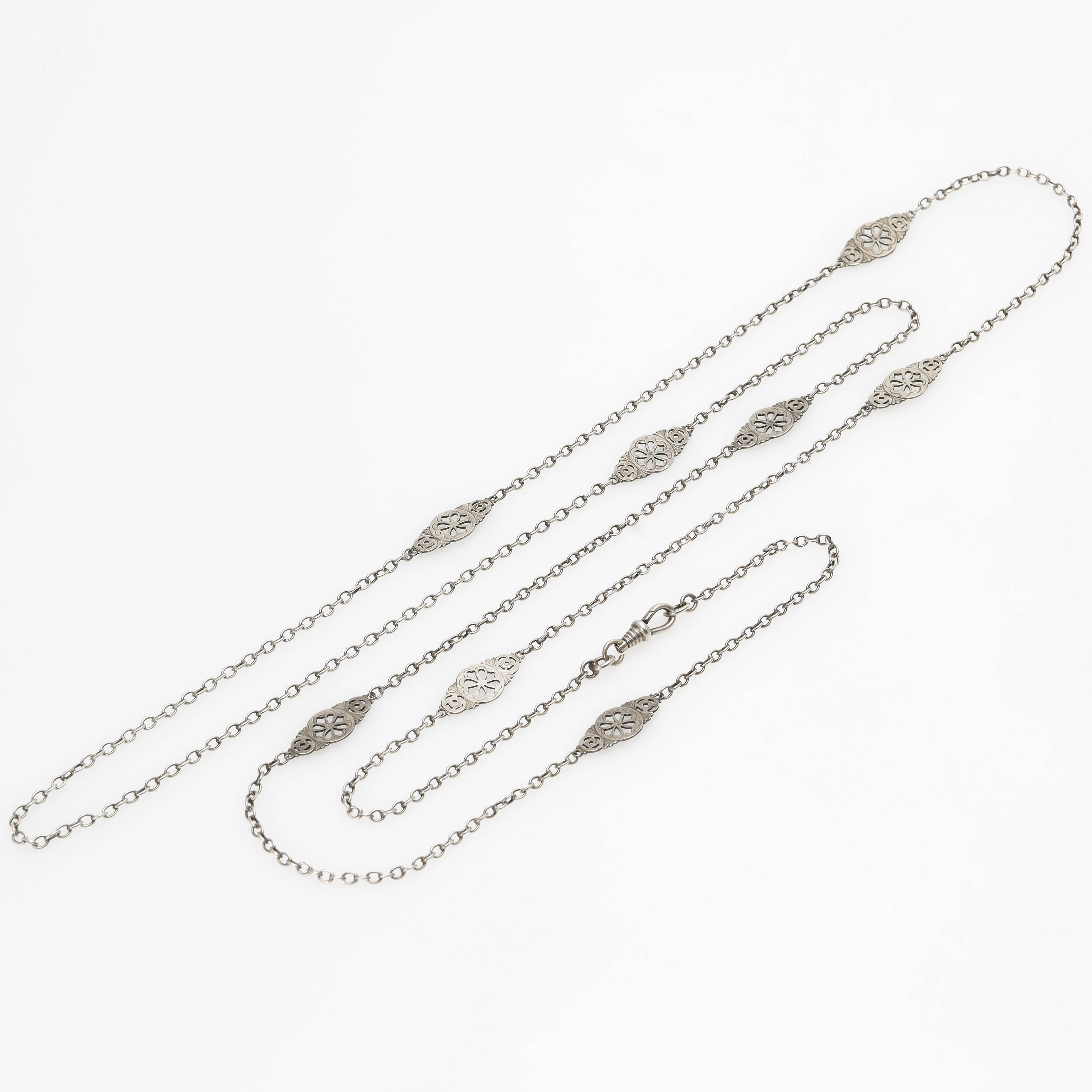 HALSKEDJA, silver, längd 139 cm, mellandelar med floristisk dekor, 1900-talets första hälft.