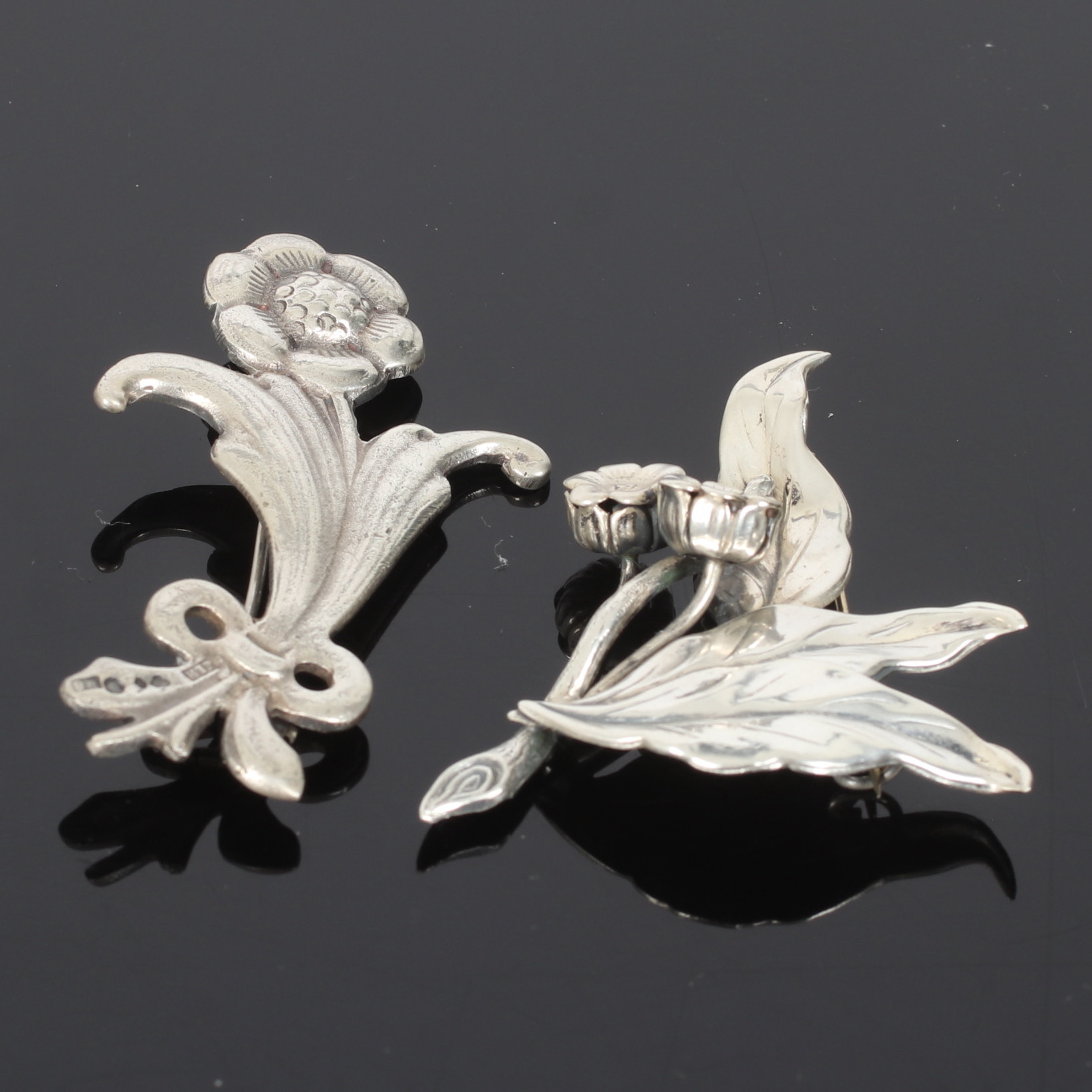 BROSCHER, 2 st. silver, med blomdekor, bl.a. J L Hultman A/B Stockholm. 1900-talets mitt.