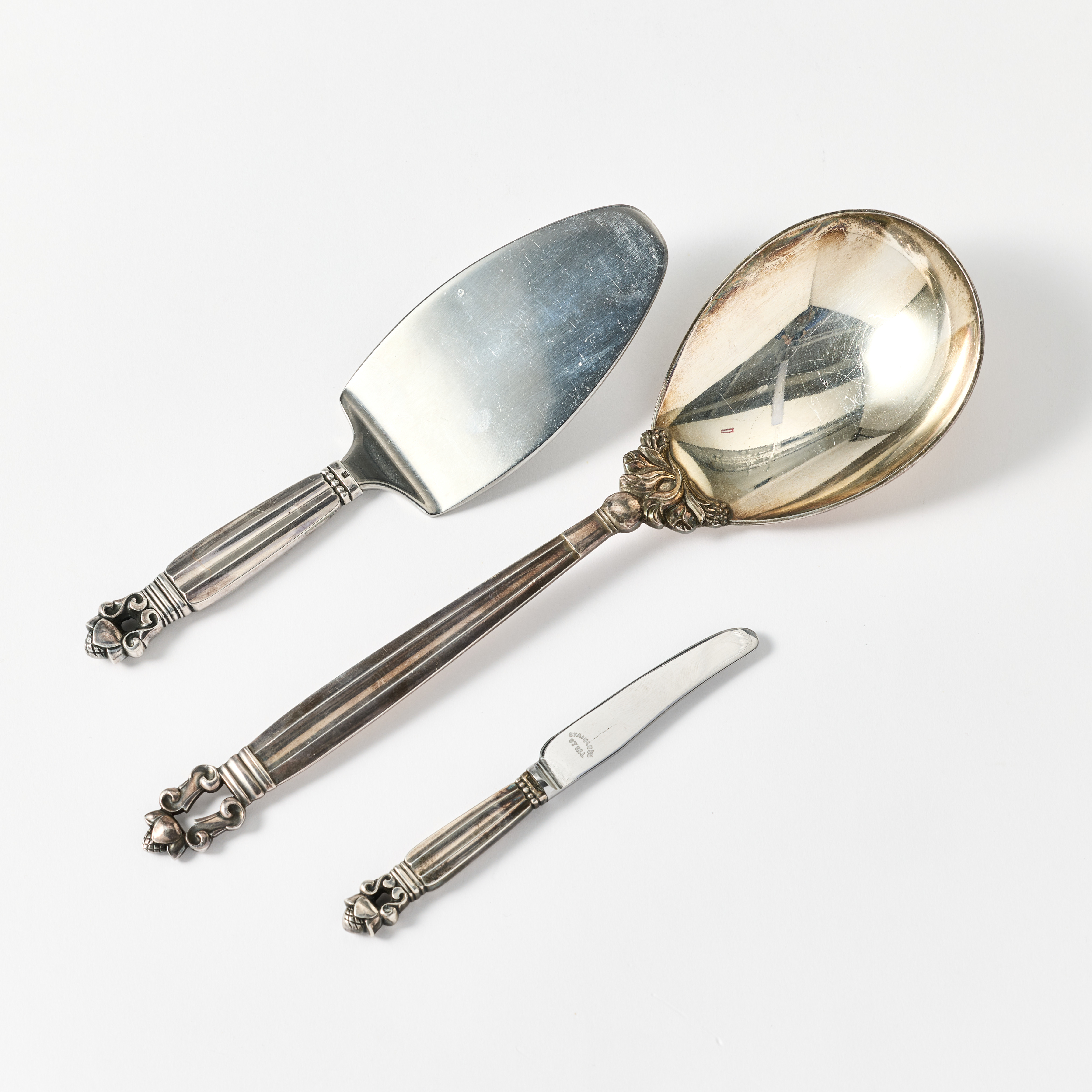 GEORG JENSEN. Uppläggningssked, sandwichspade och liten kniv med läderfodral. Danmark 1933-1944 och 1945-1951. Modell Konge/Acorn.