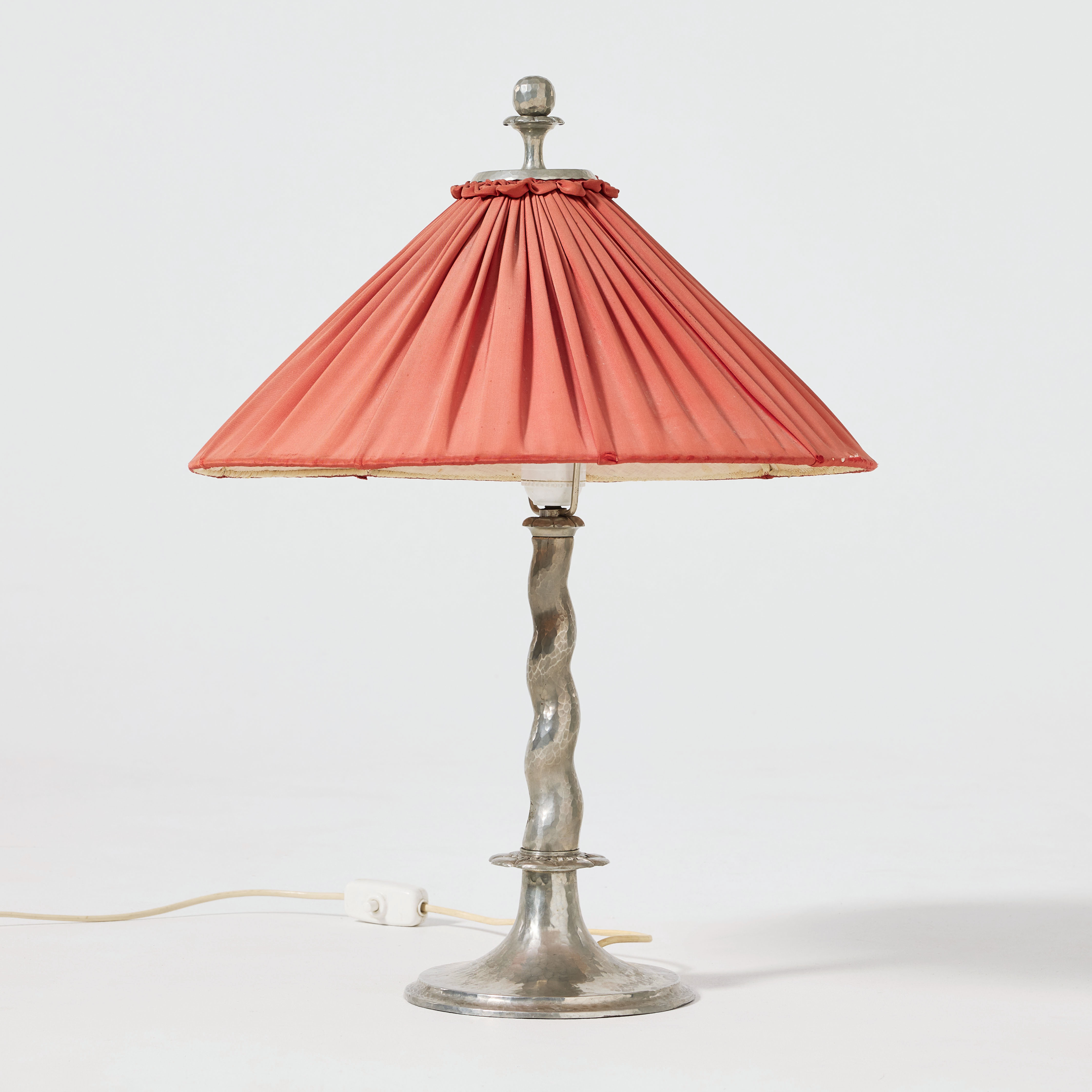 HARALD NOTINI. Bordslampa, Arvid Böhlmarks Lampfabrik, Stockholm 1920-tal, modell 6891, hamrat tenn, skärm klädd i rosa veckat siden, kantband med vita fransar.