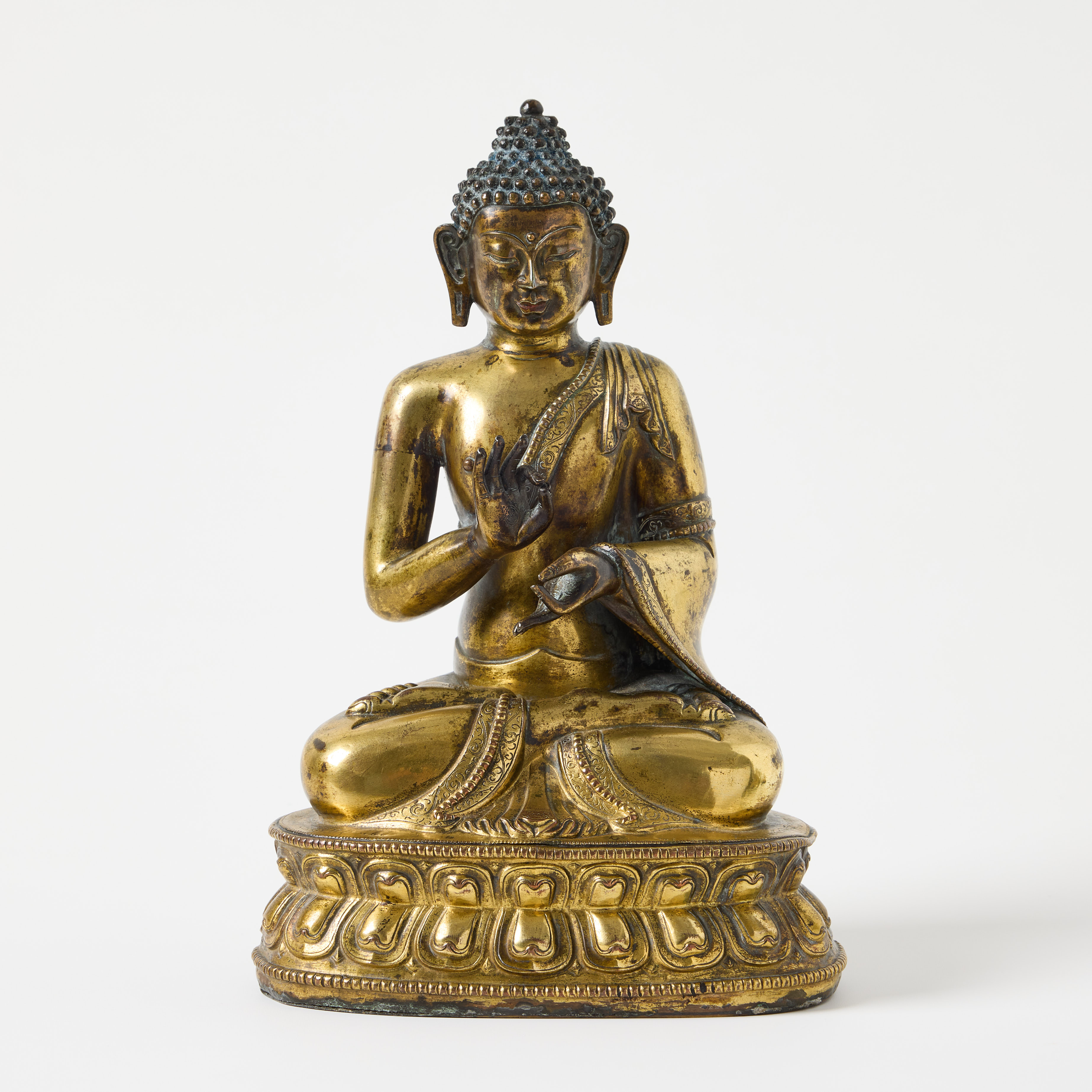A Tibetan Gilt Copper Repoussé Figure of Dipankara Buddha.