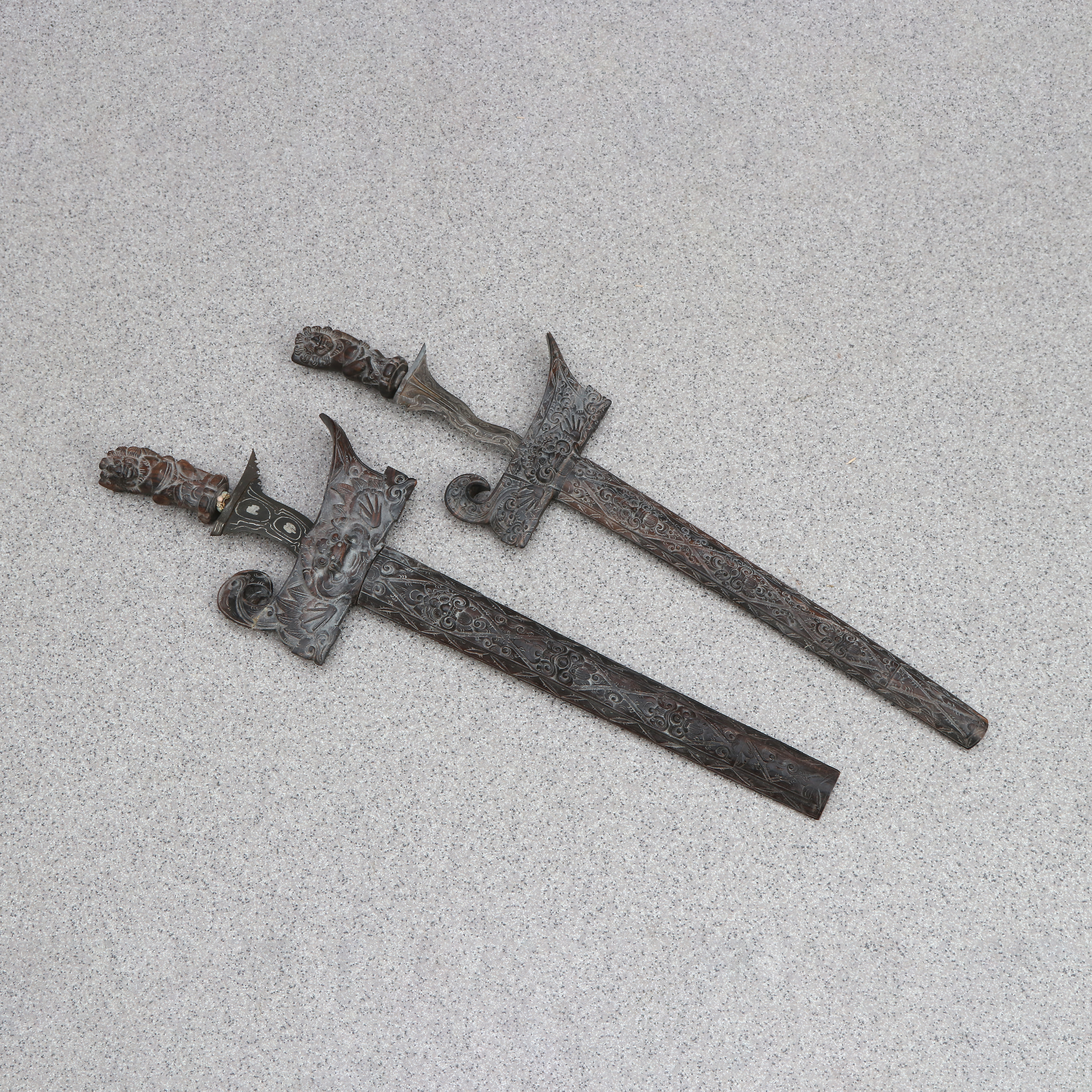 KRIS, TVÅ ST. Skuret trä med smidda klingor. Indonesien, 1900-tal.