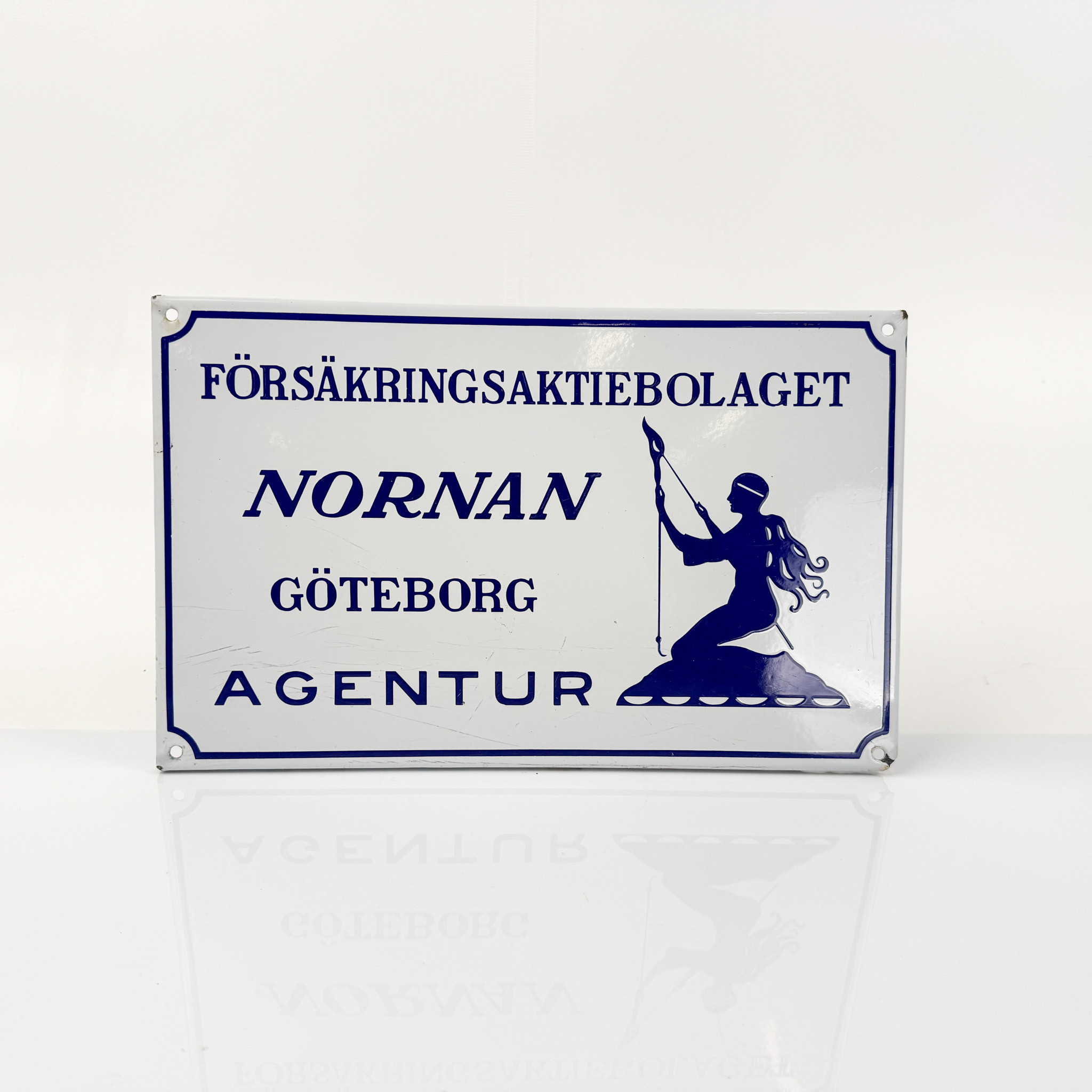 NORNAN, emaljskylt, 1900-talets förstahälft.