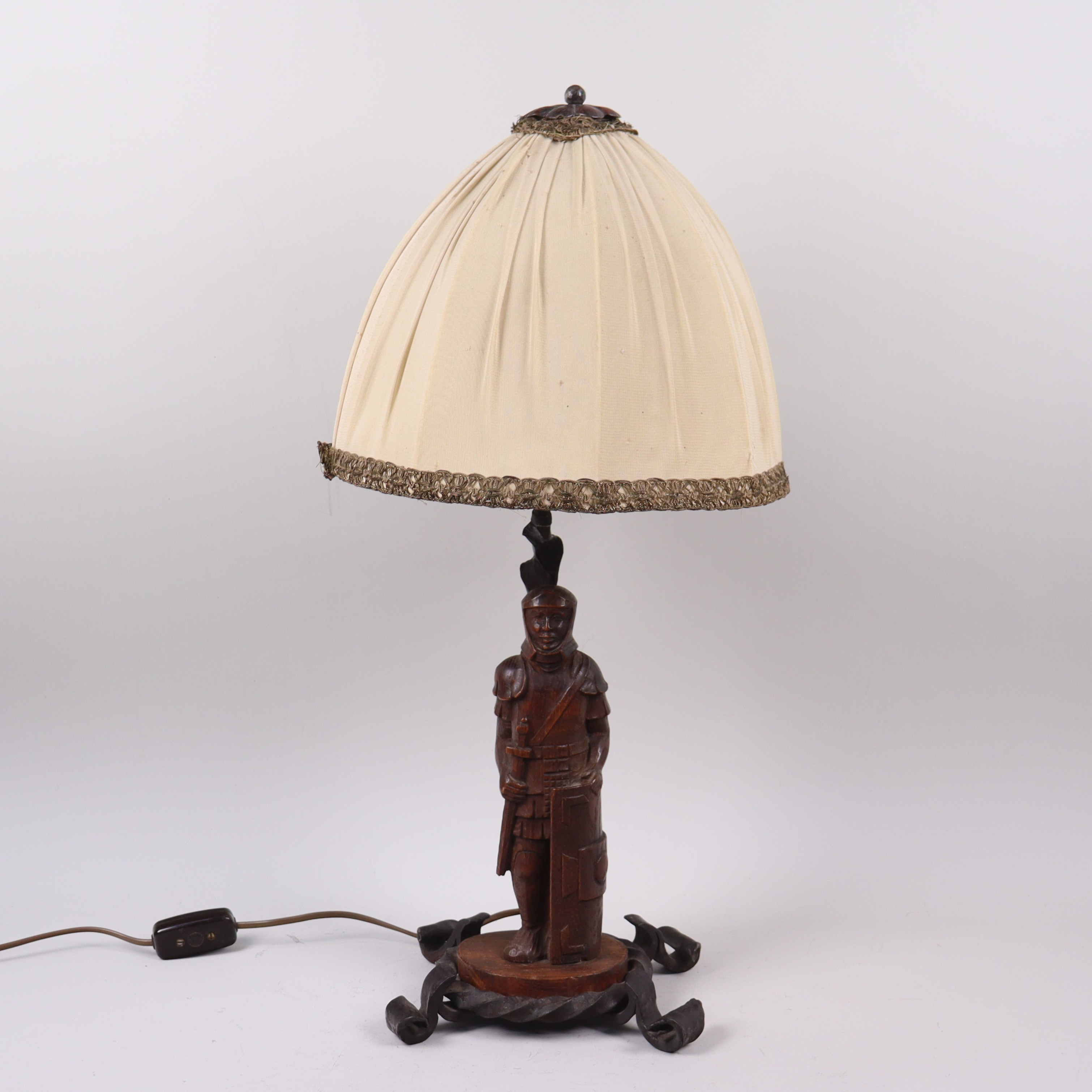 BORDSLAMPA, järnsmide med snidad figurin i form av krigare / riddare i trä, 1900-talets första hälft.