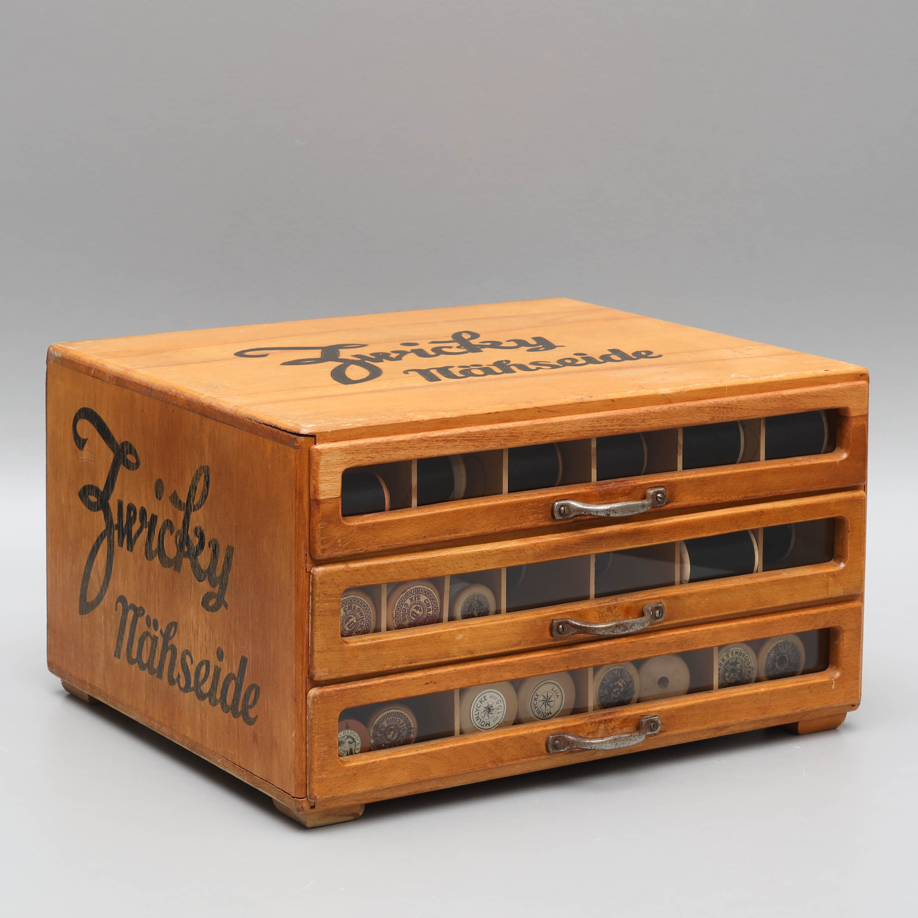 MONTERSKÅP, för sytrådsrullar, trä/glas, Zwicky nähseide 1900-talets mitt.