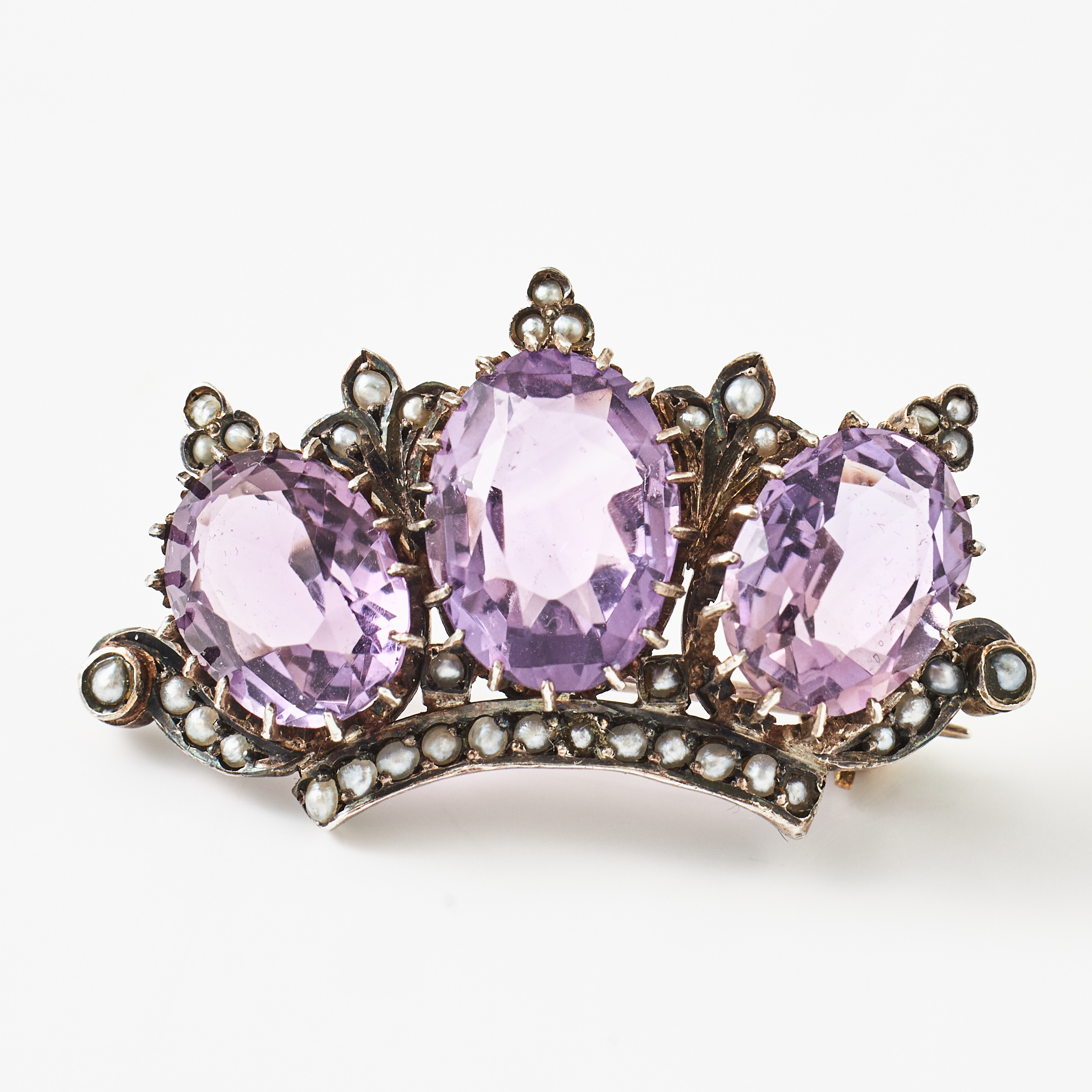 BROSCH, silver/900, spår av förgyllning, i form av en krona, 3 ovala fasettslipade ametister samt dekor av orientpärlor, Wien/Österrike (1867-1872).