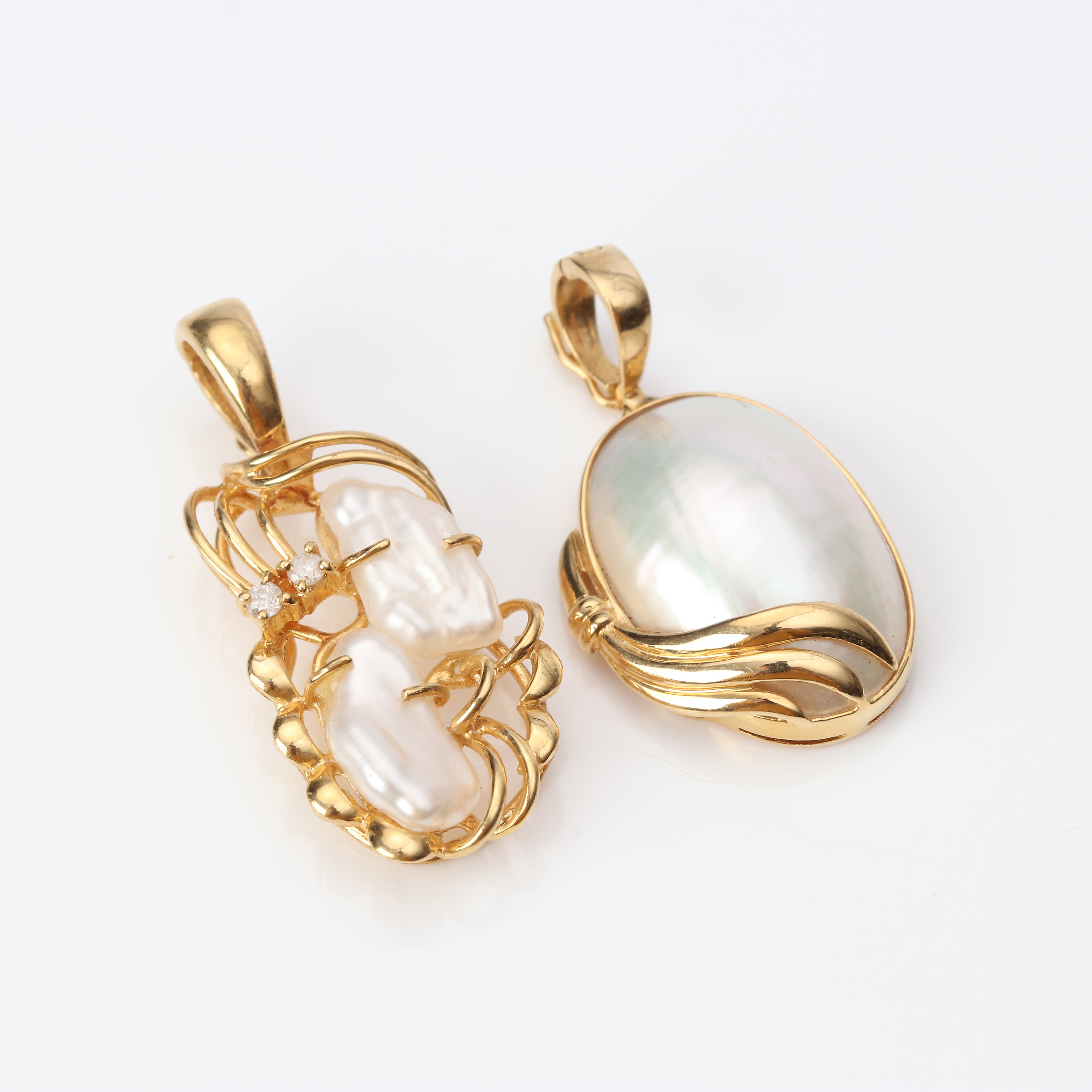 HÄNGEN, TVÅ ST. 18k guld med odlad mabepärla och sötvattenpärlor med briljantslipade diamanter, totalvikt ca 7,0 gram.