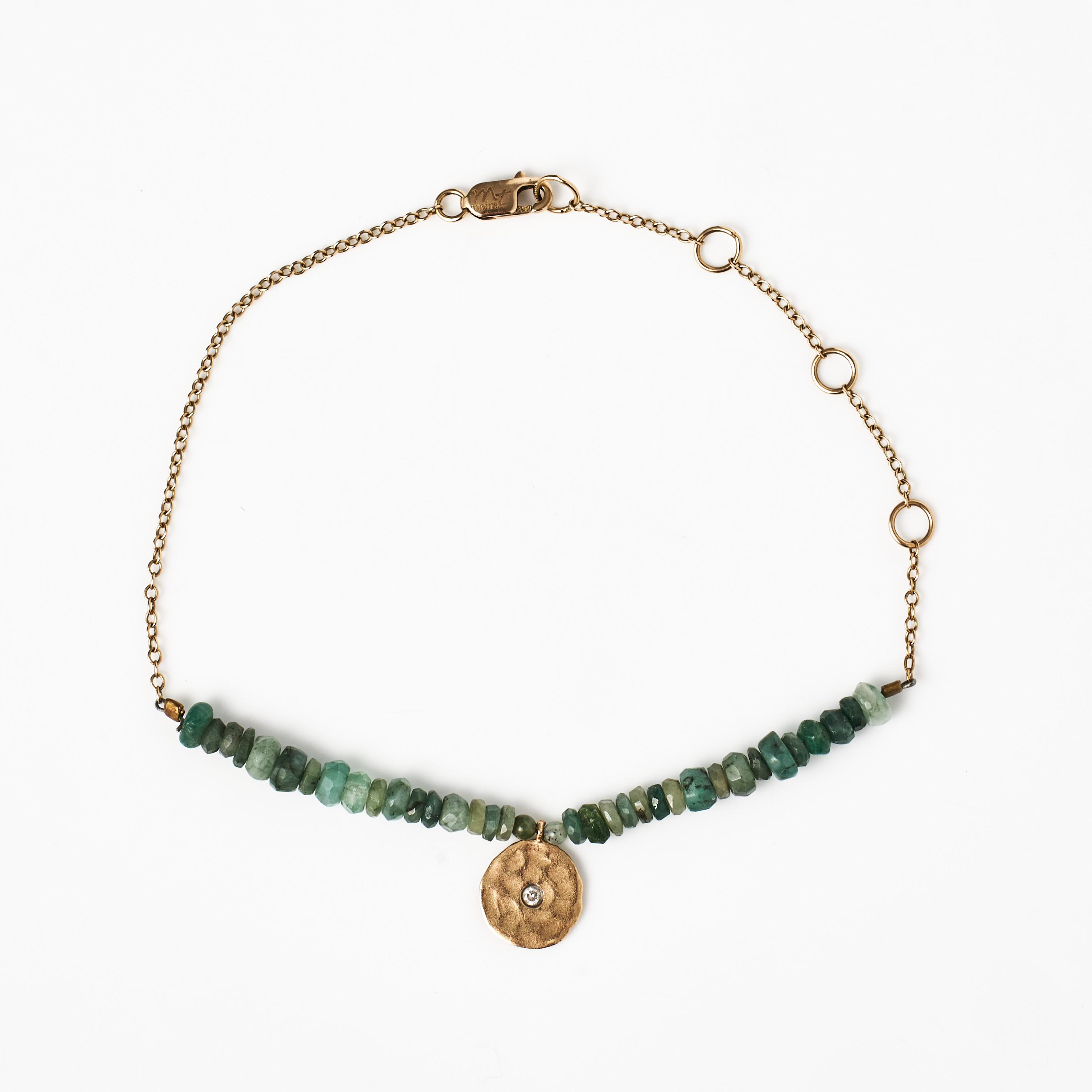 ARMBAND, 14 k guld, mittparti med trumlade smaragder samt berlock med hamrad dekor och briljant ca 0,02 ct.