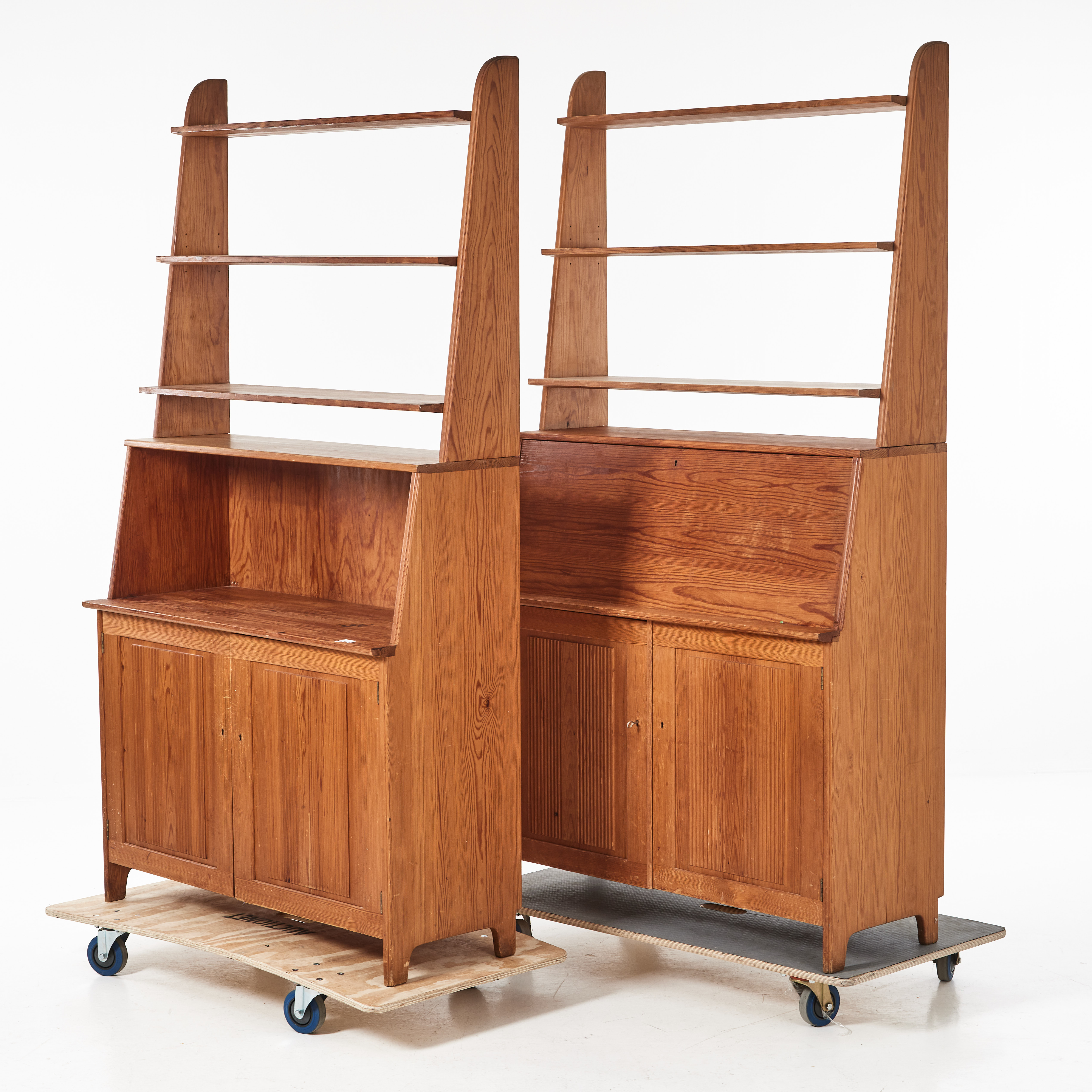 CARL MALMSTEN. Bokhylla/skåp, 2 st, "Visingsö", 1900-talets mitt, tvådelade, fur, underdelar med två dörrar, bakomliggande hyllplan och lådor, överdel med tre hyllplan, en del med skrivdel.