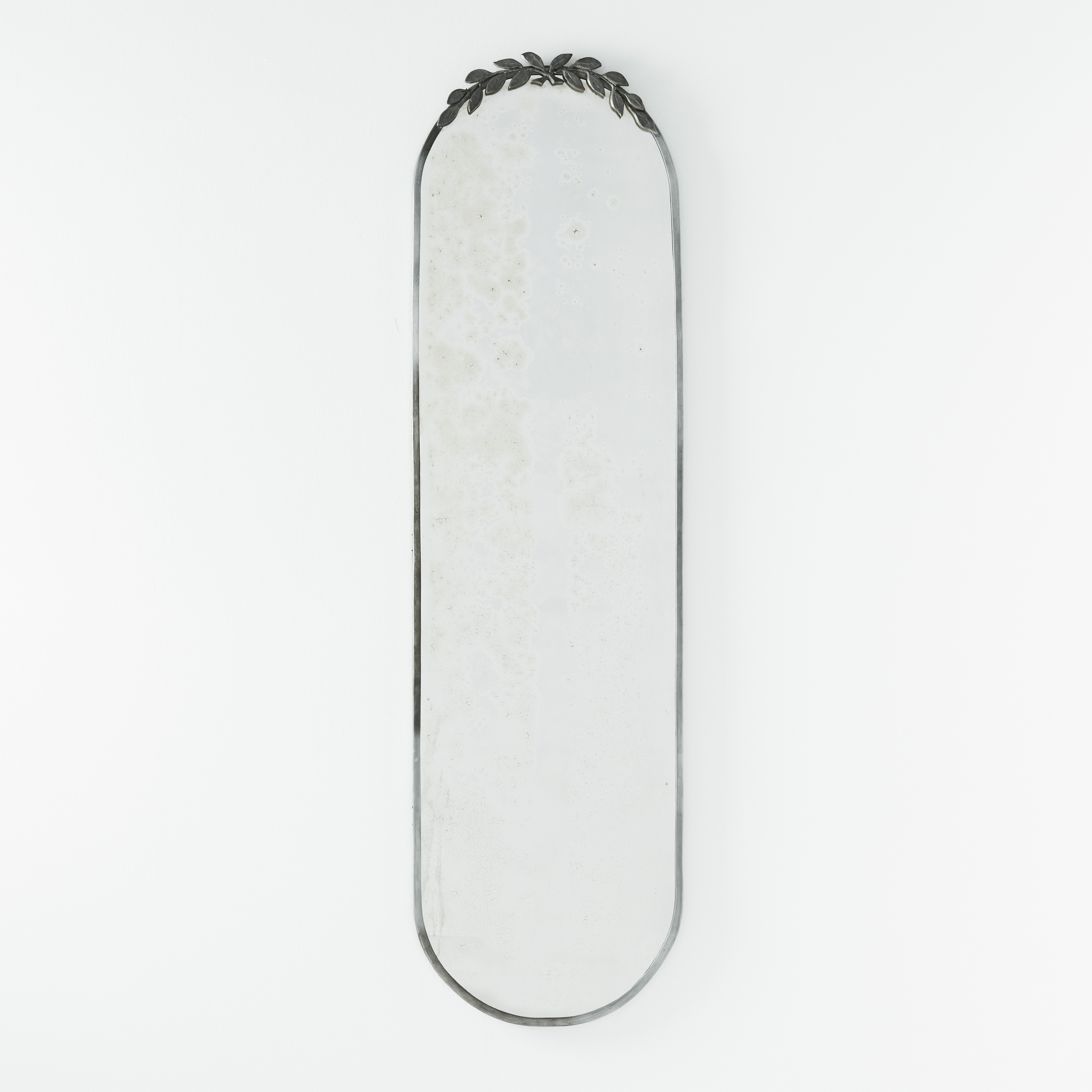 SPEGEL, Sverige 1940-tal, tenn, oval med slät ram, i överkant med dekor av korslagda lagerkvistar.