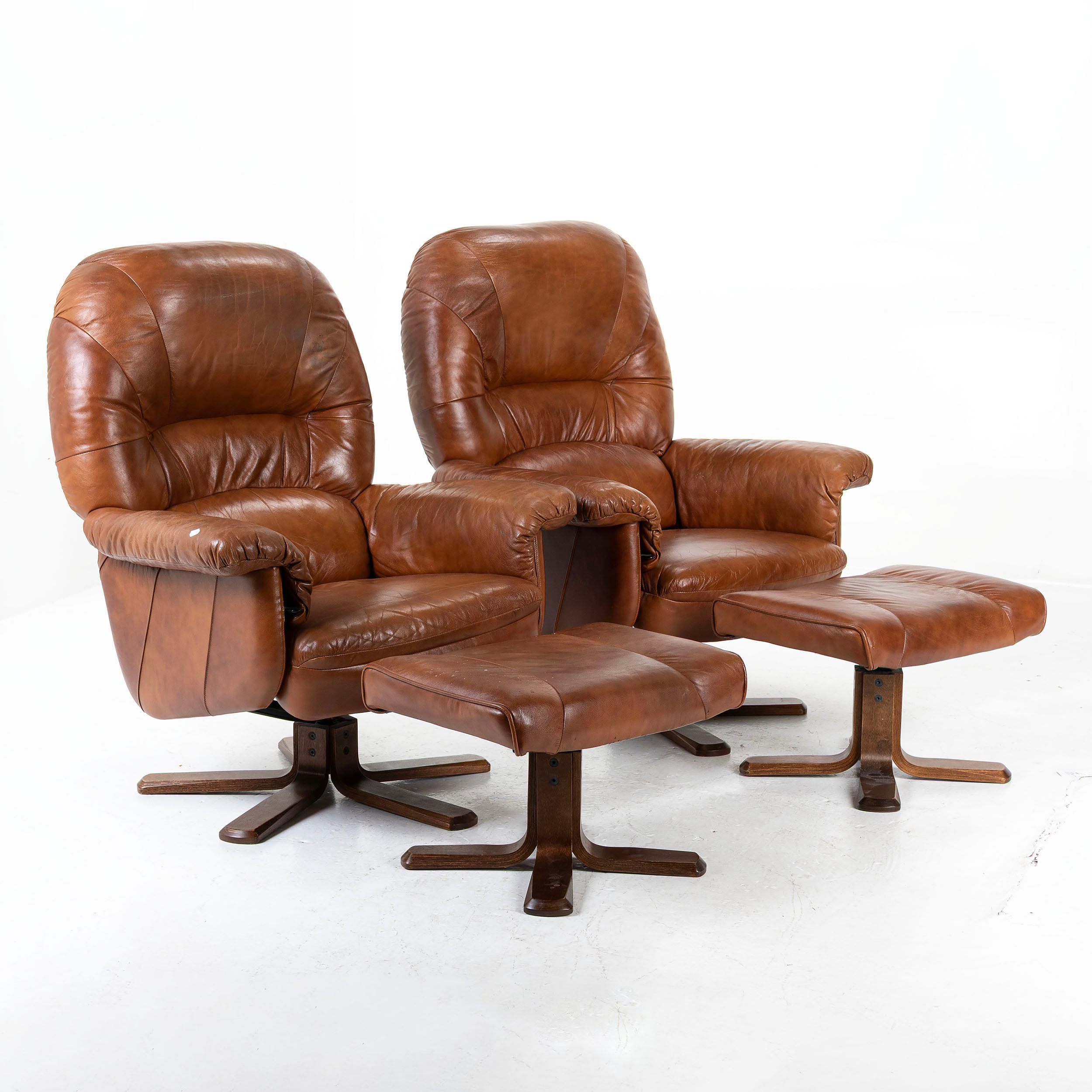 SKINNFÅTÖLJER, ett par, med fotpallar, 1900-talets senare del.