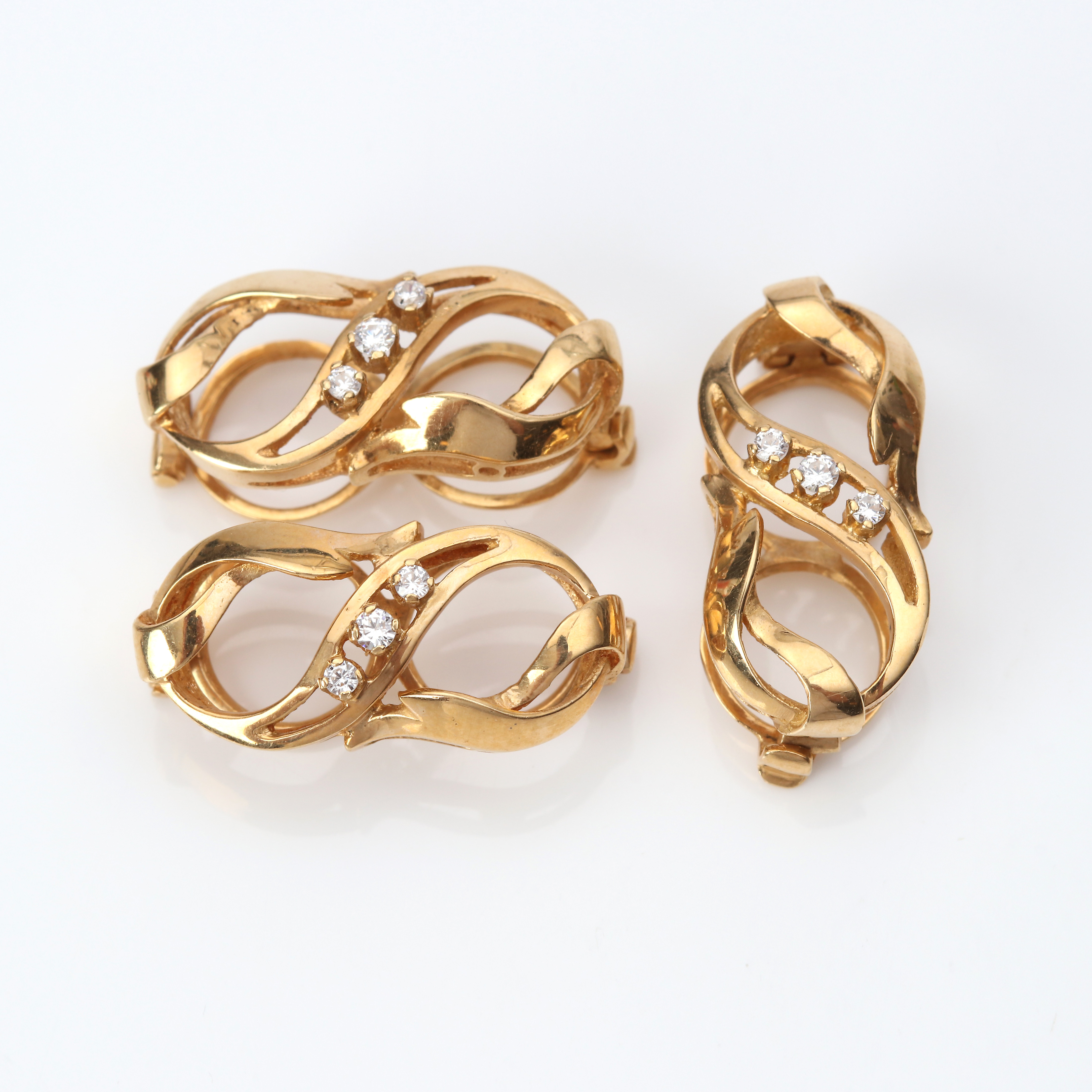 COLLIERSPÄNNEN, TRE ST. 18k guld med cubic zirkonia, totalvikt ca 7,1 gram.