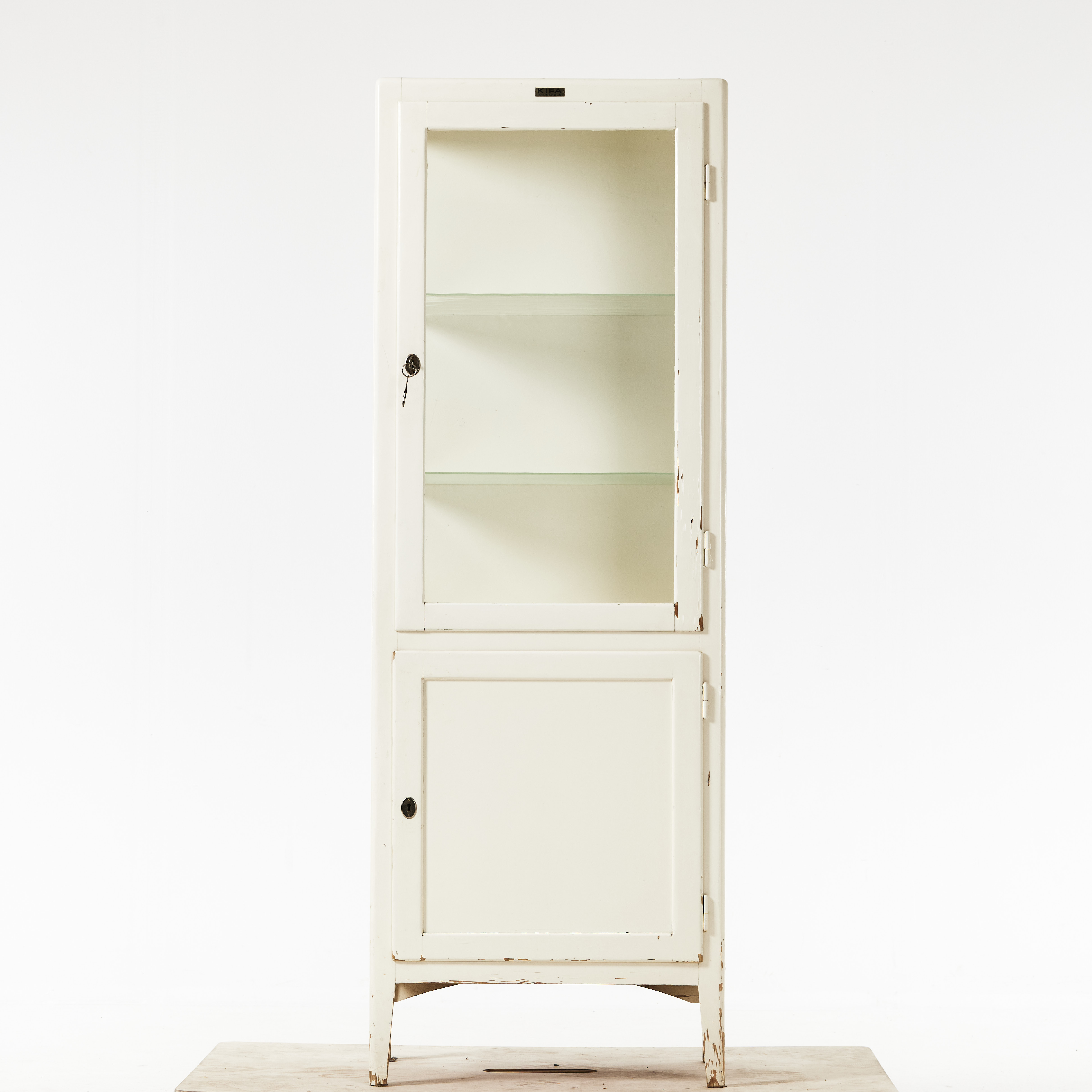 LÄKARSKÅP, stomme i vitmålad trä, skåpdörrar delvis i glas, bakomliggande hyllplan, brickmärkt, Kifa, 1900-talets mitt.