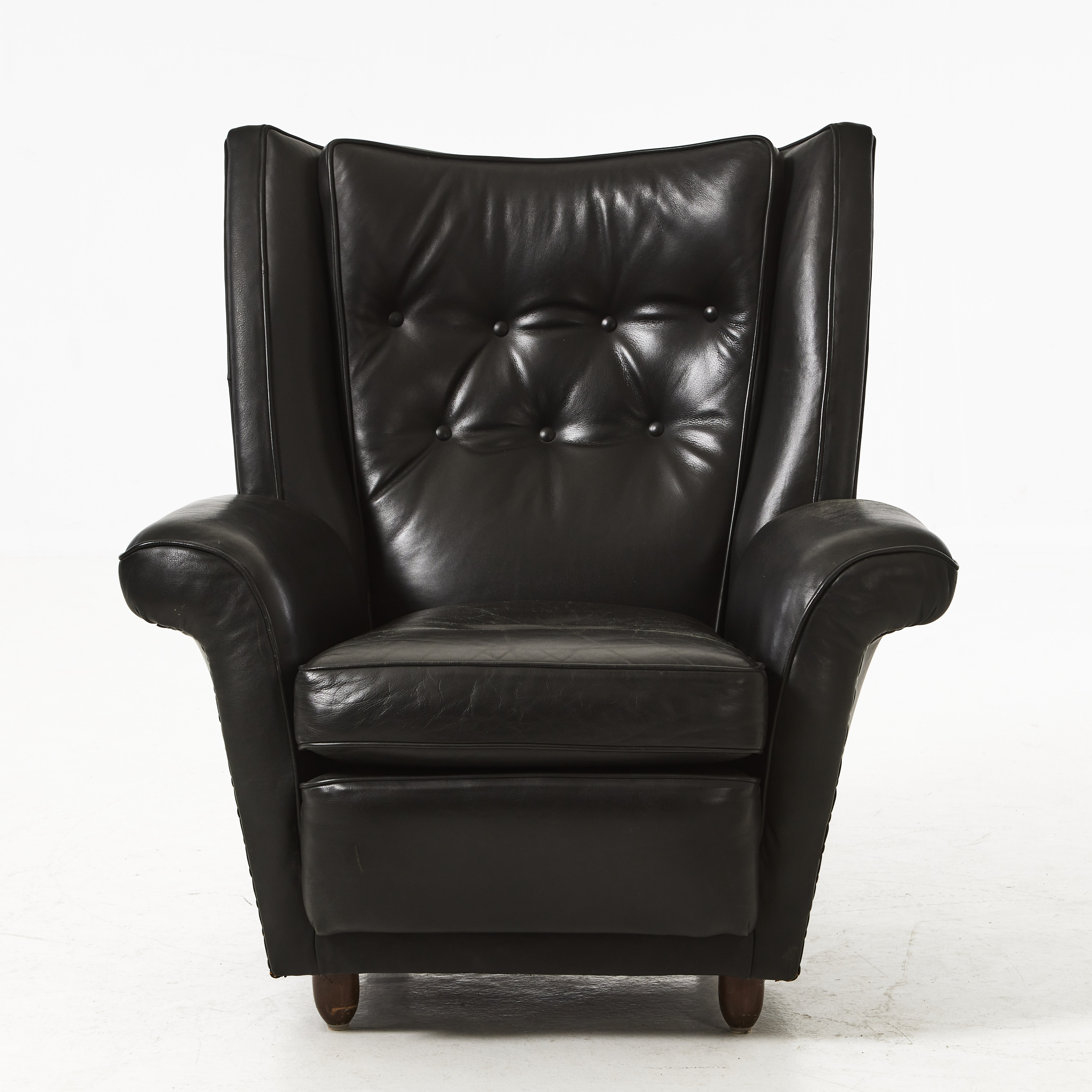 FÅTÖLJ, 1950-tal, svart skinnklädsel, ben i betsad bok.