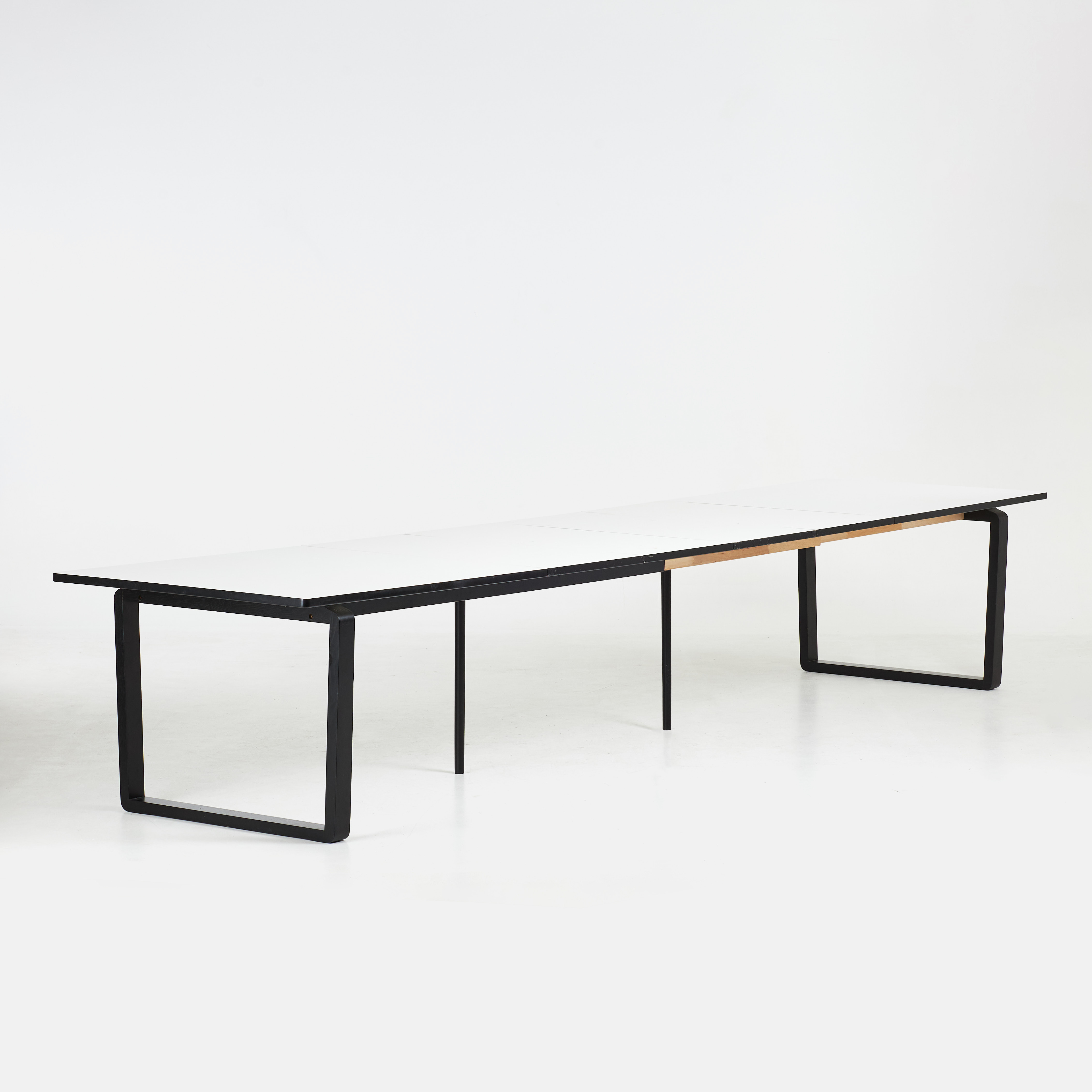 GLISMAND & RÜDIGER. Matbord "DT20", samtida, Bolia, Danmark, skiva i vit laminat, benställning av svartbetsad ek, med 4 iläggsskivor.