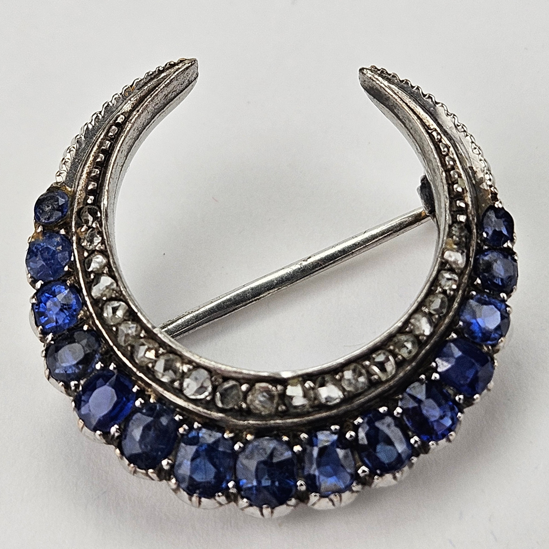 BROSCH, månskära, vitguld, 14K, ostämplad, med stenar, bland annat diamanter, total vikt ca. 5,5 gram.