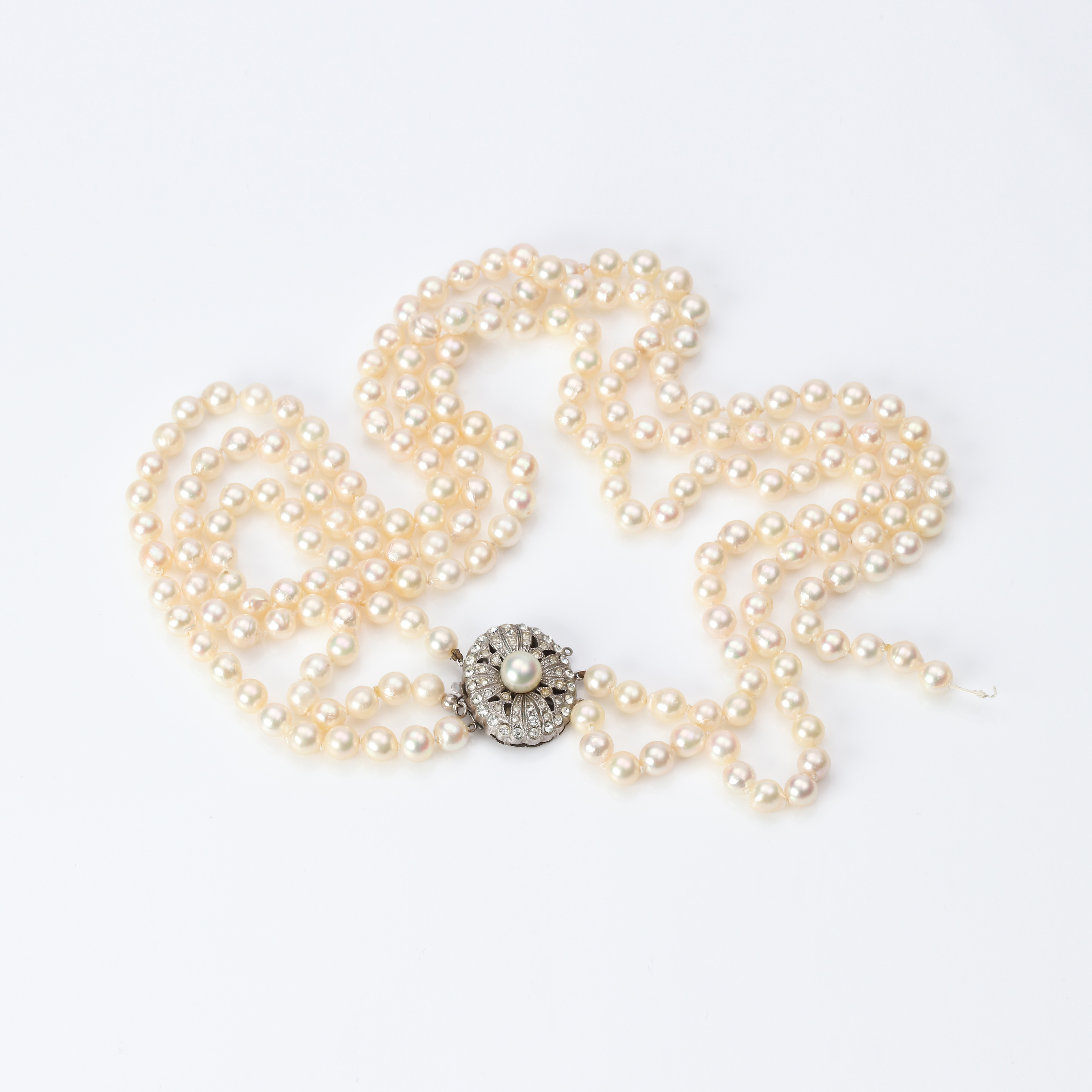 PÄRLCOLLIER. Odlade pärlor i tre rader, lås i silver med färglösa stenar och en odlad pärla.