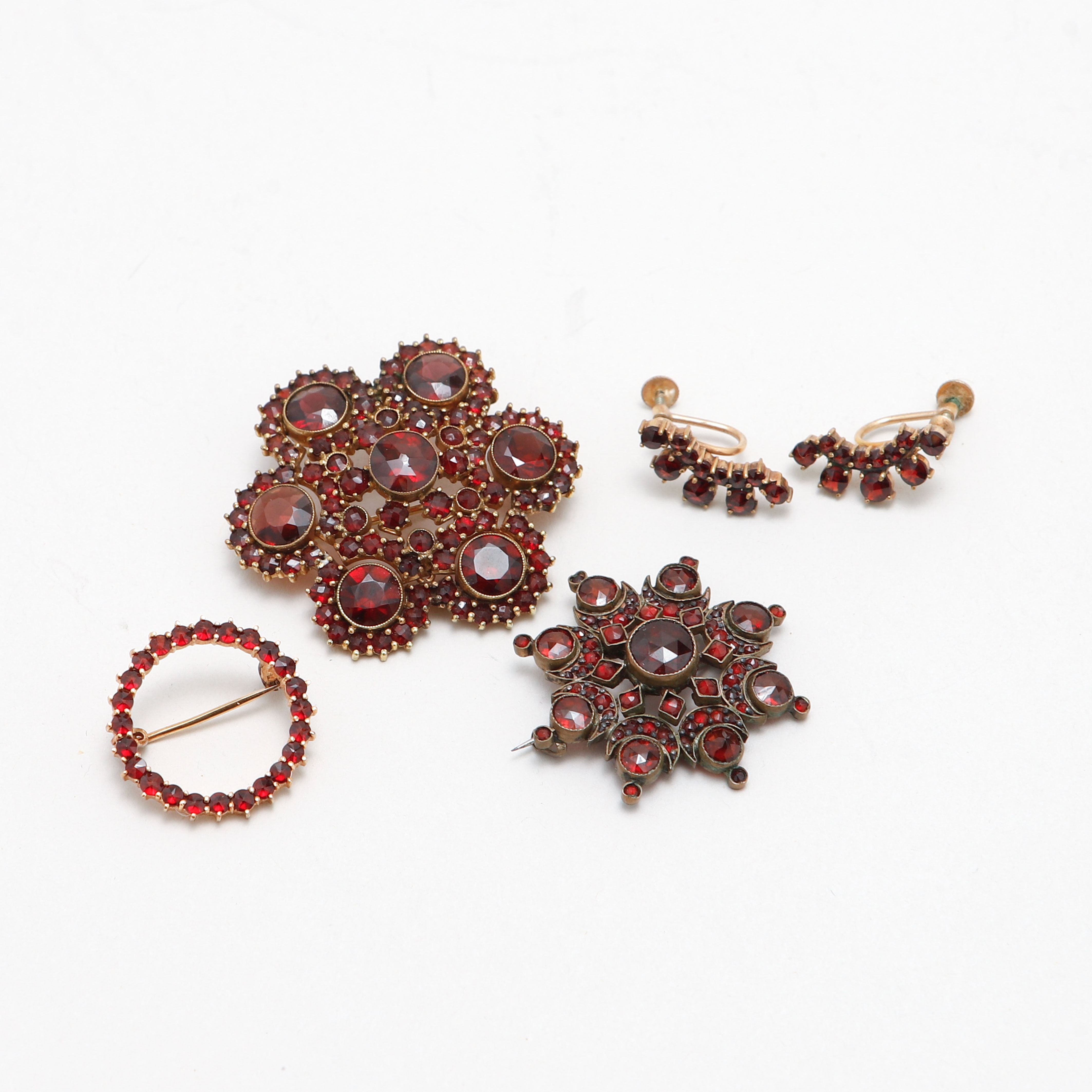 BROSCHER, 3 st, samt ÖRHÄNGEN, ett par, förgylld metall, granater.