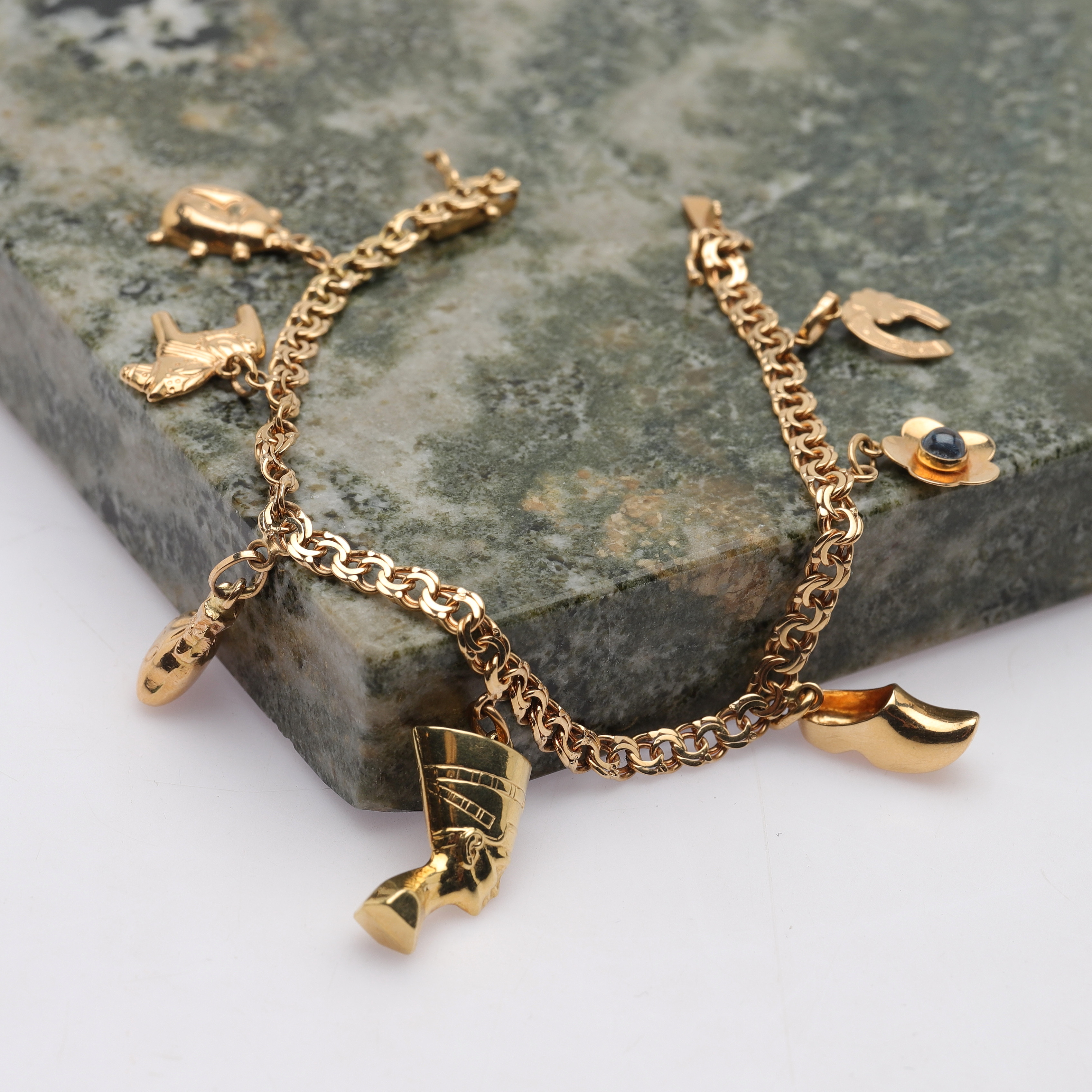 BERLOCKARMBAND, 18k guld, bismarck-länk, 7 st berlocker, Tor Ahlberg Nordguld, 1958, totalvikt ca 12,8g.