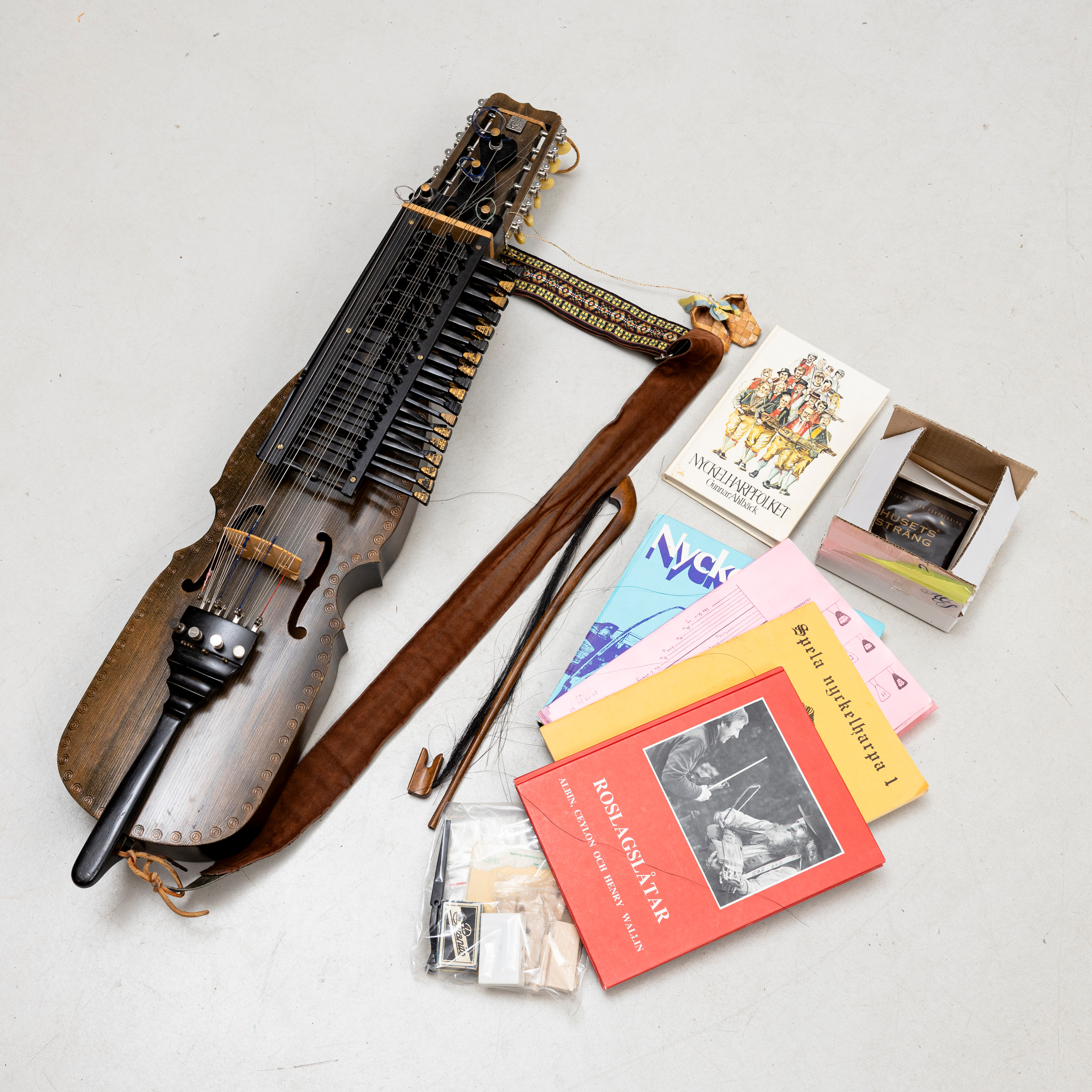 NYCKELHARPA, signerad, daterad 1985, med stråke, tillbehör och böcker.