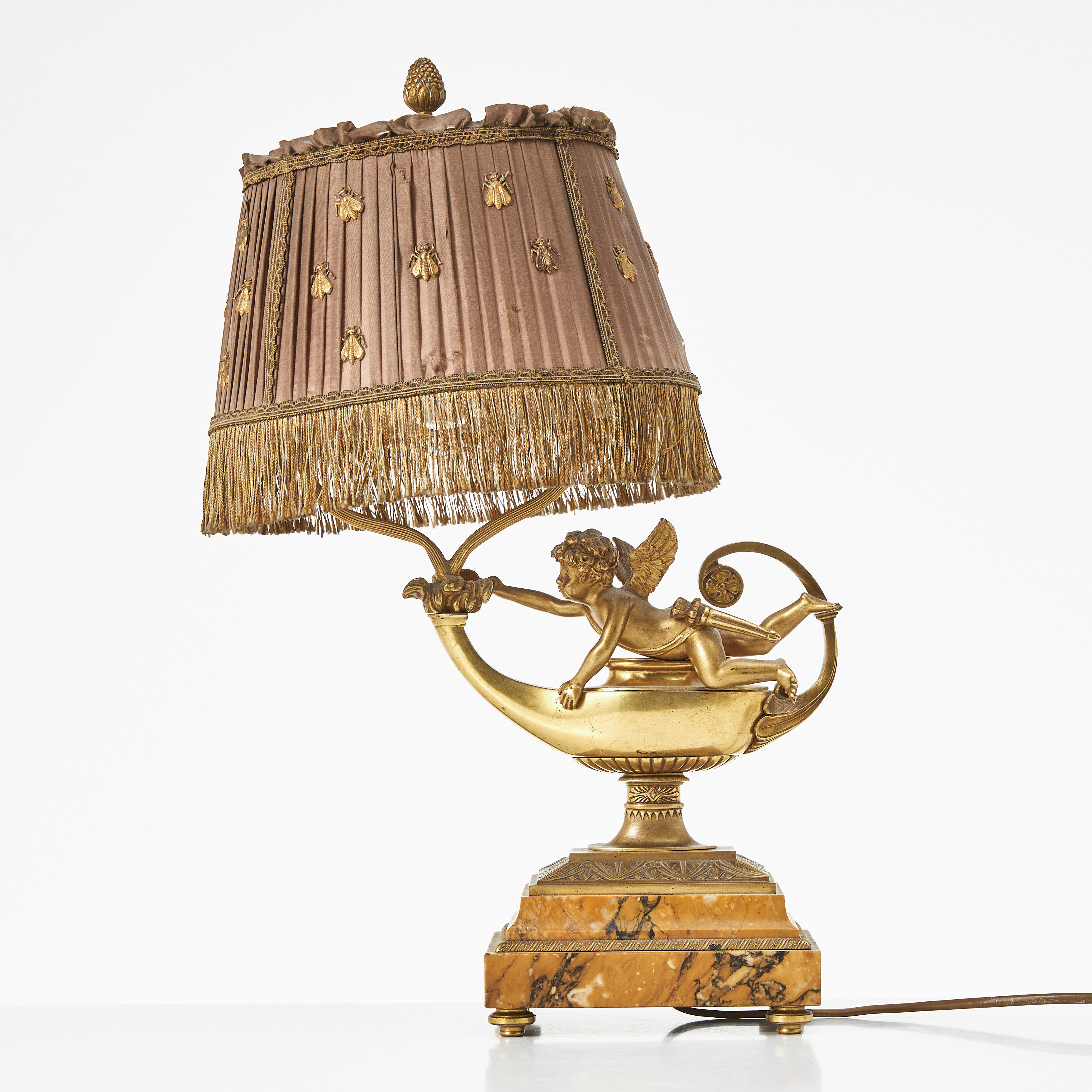 BORDSLAMPA, empirestil, förgylld och patinerad mässing i form av oljelampa och Amor. Bas av marmor, textilklädd skärm.