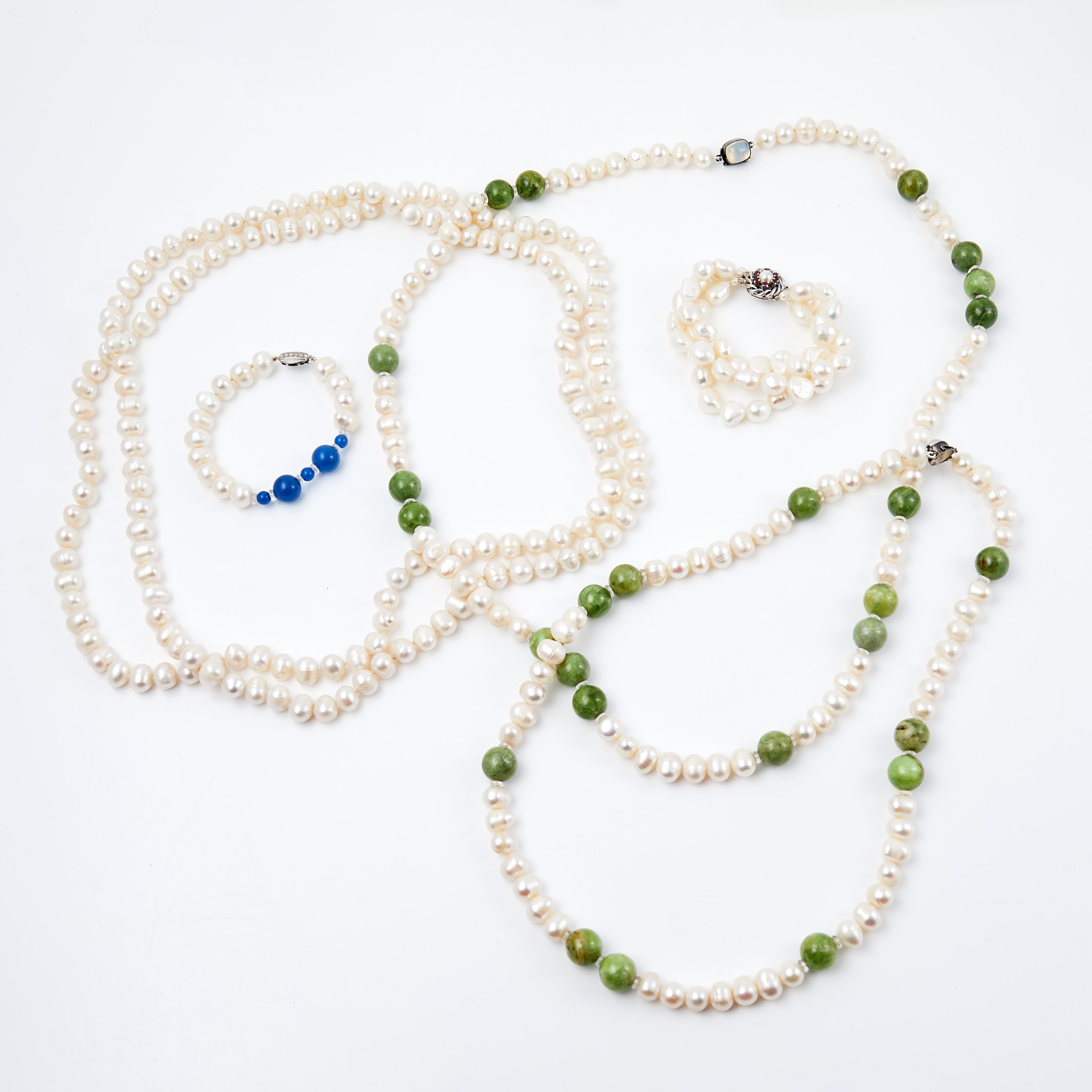 HALSBAND, 3 st, ARMBAND, 2 st, odlade vita sötvattenspärlor, kulslipad serpentin, kulslipat blått glas, fasettslipad bergkristall, lås i silver, med månsten, strass, rubiner, bl. a. J. Köhle från Pforzheim, Tyskland samt svenska importstämplar.