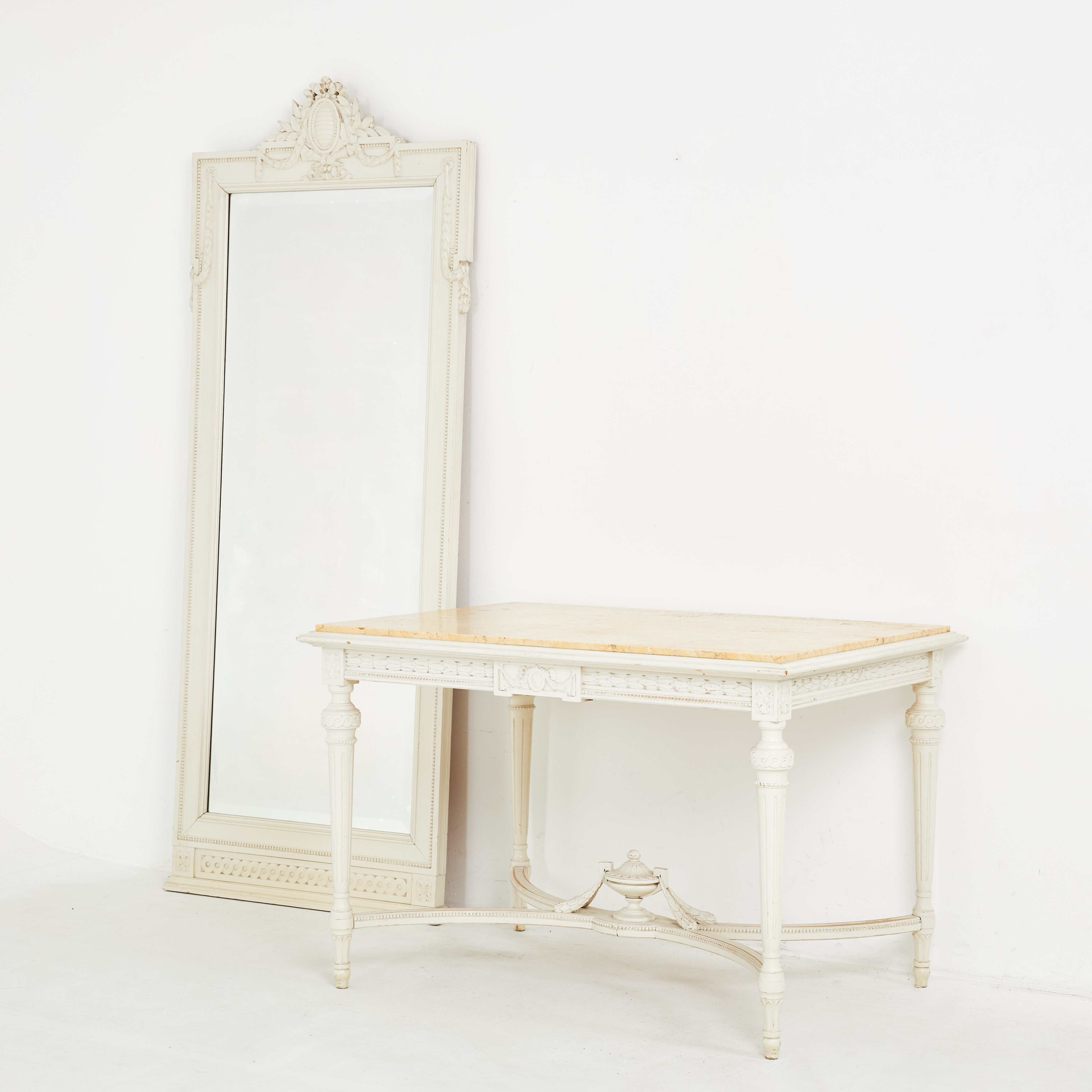 SPEGEL och BORD. 1900-tal, träskuren dekor, kalkstens skiva, kopplad benställning urna, fasetterat spegelglas.