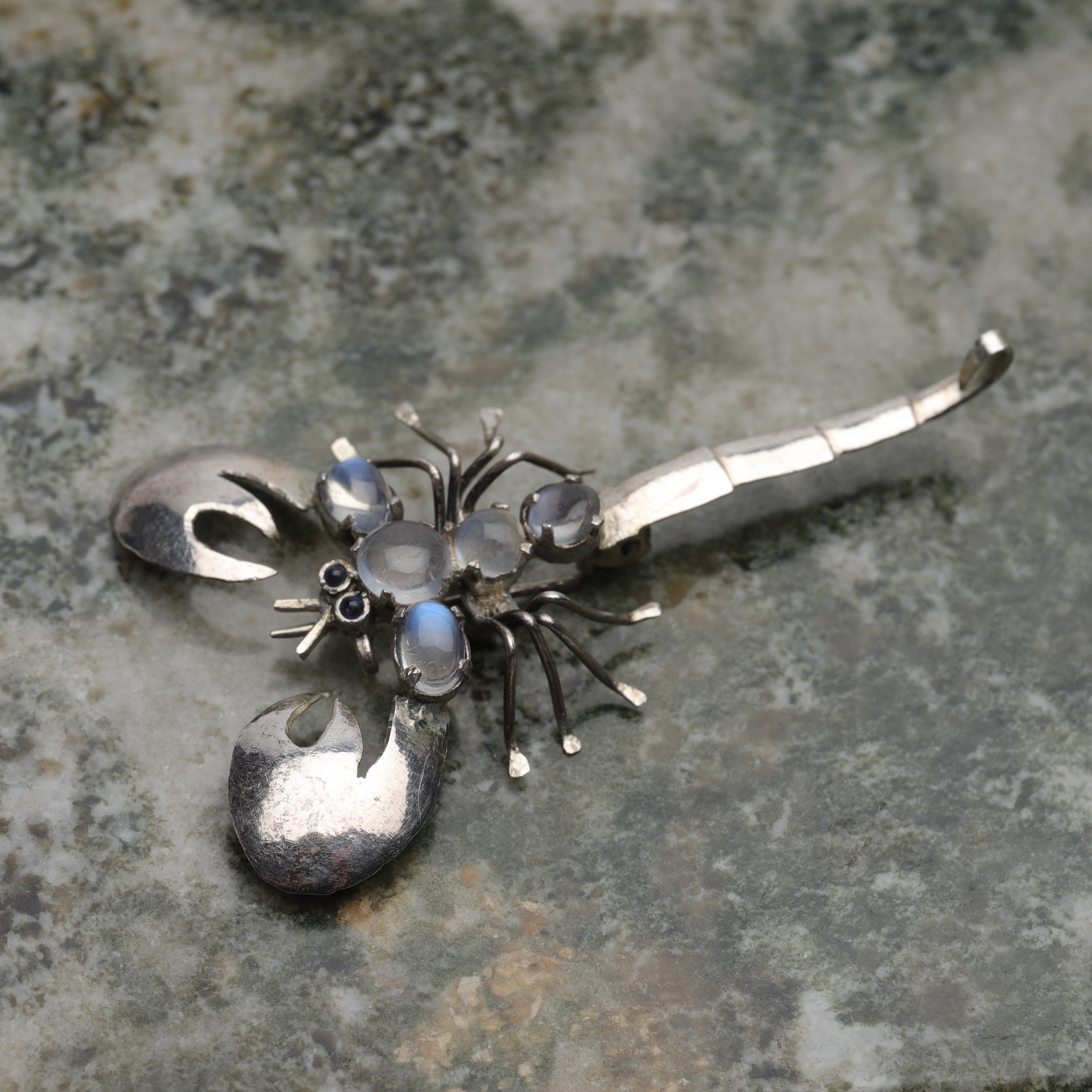 BROSCH, silver med cabochonslipade månstenar, skorpion, 1900-tal.