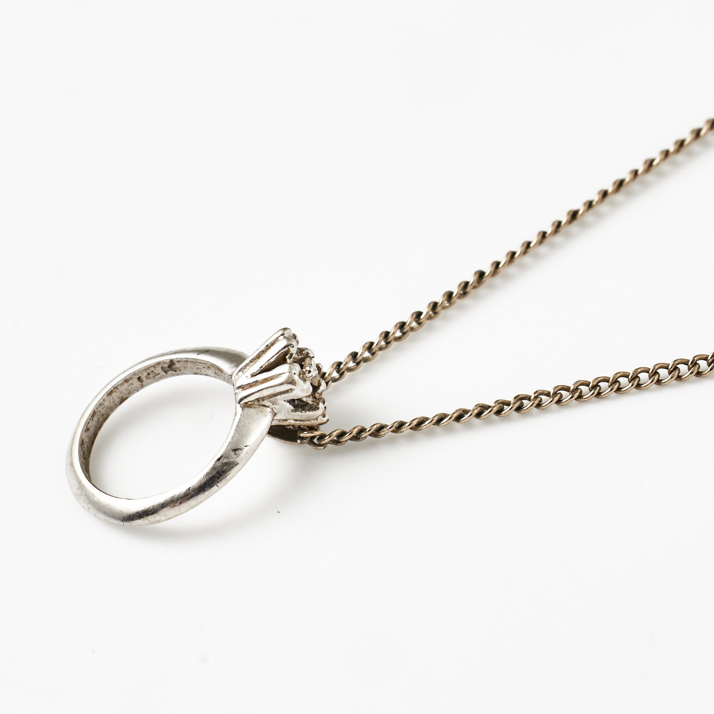 HALSKEDJA MED HÄNGE, 14 k vitguld, i form av en ring med dekor av en liten åttkantslipad vit sten.