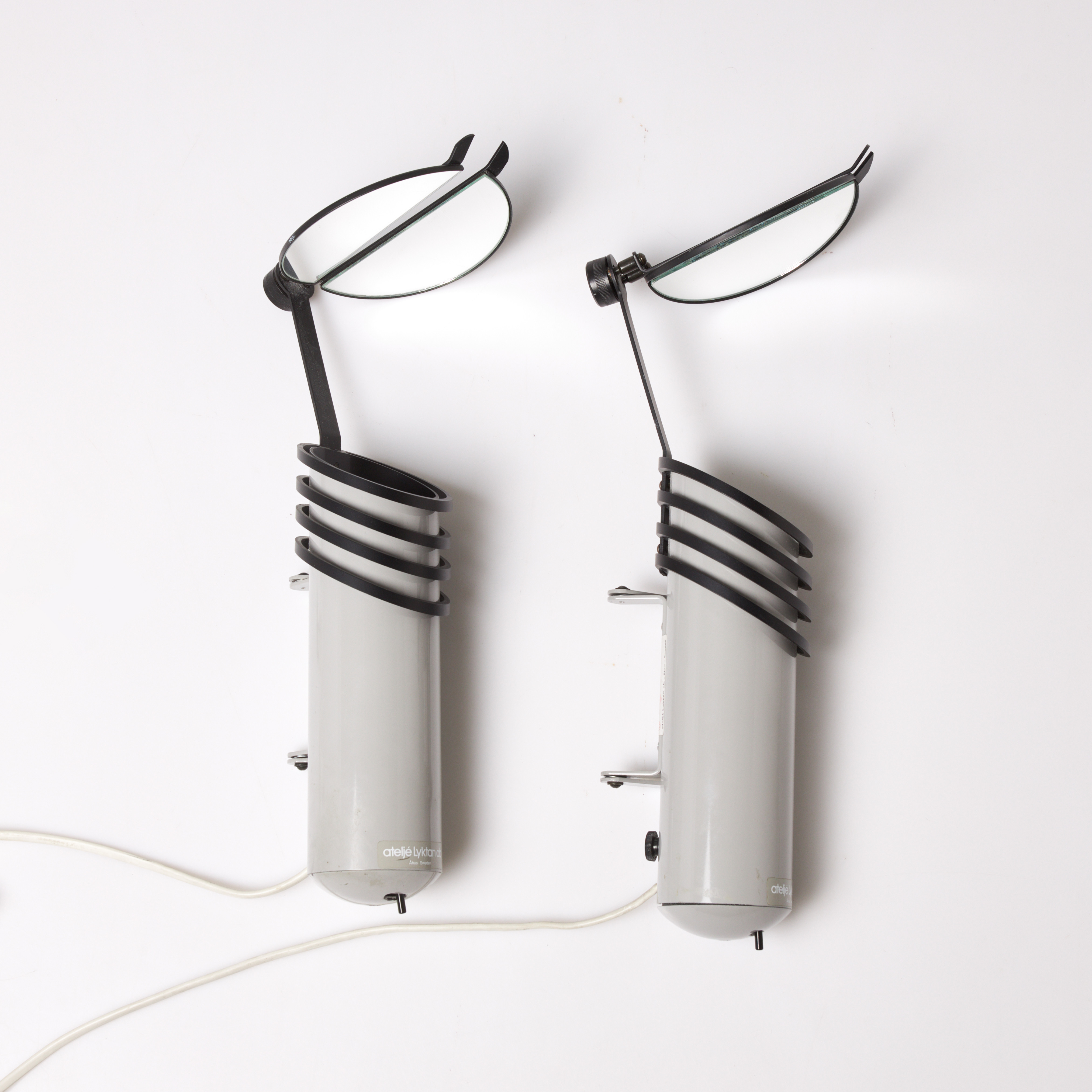 VÄGGLAMPOR. 1 par, "Skarabé", för Atelje Lyktan, lackerade i grått, etikettmärkta.