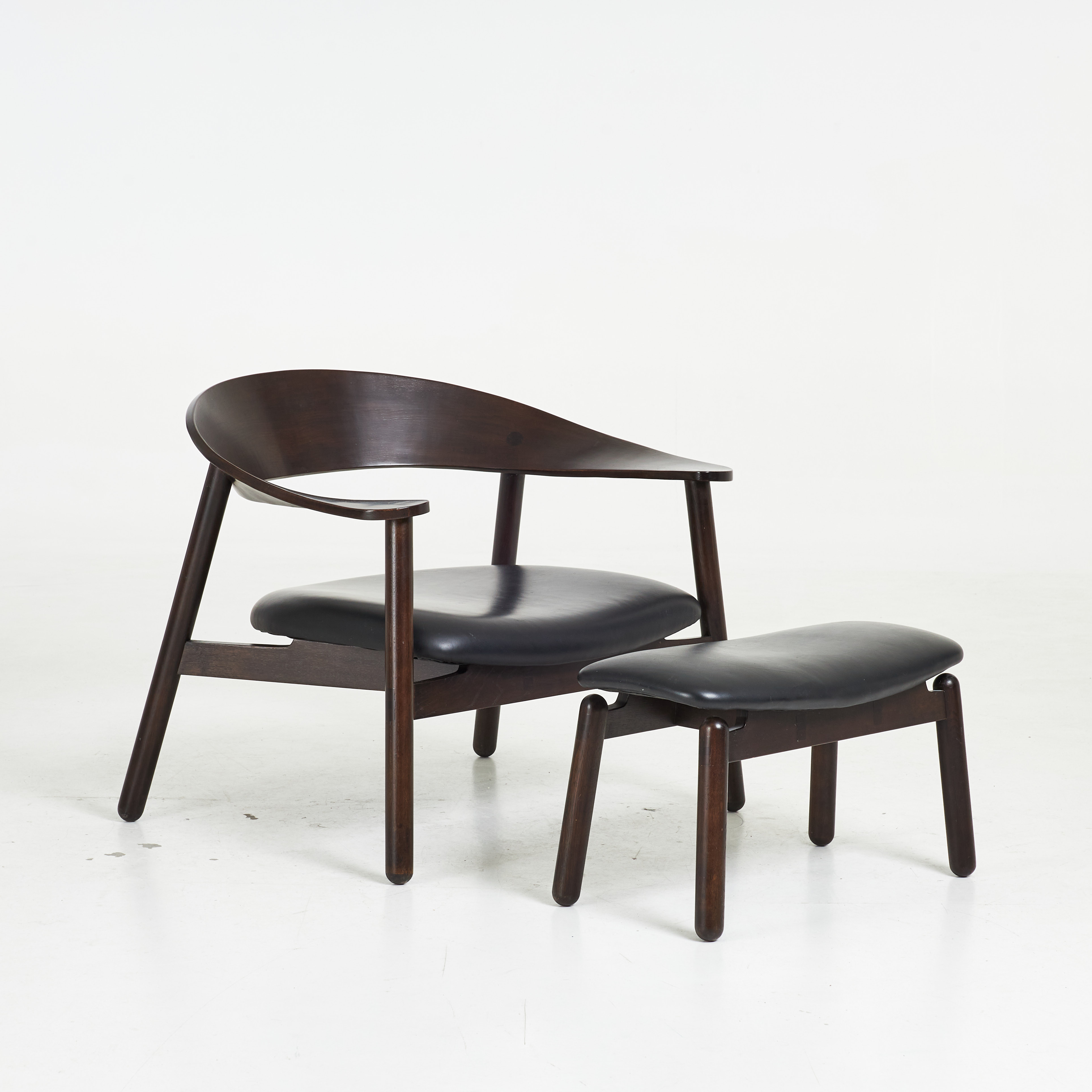 HENRIK BØNNELYCKE. fåtölj med pall, för Silo, Danmark, mörkbetsat trä samt klädsel i svart skinn.