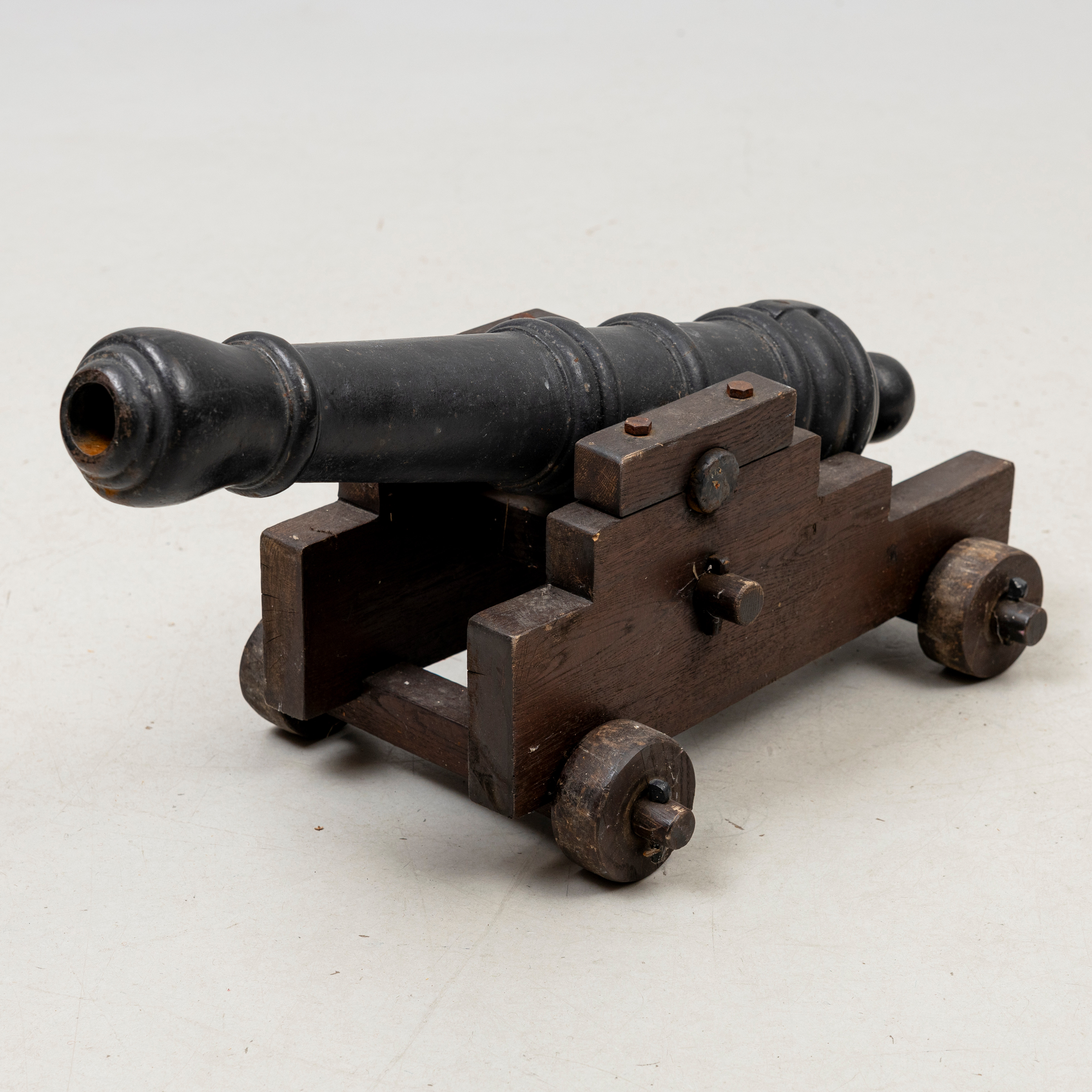 SALUTKANON, gjutjärn, omärkt, på trälavett.