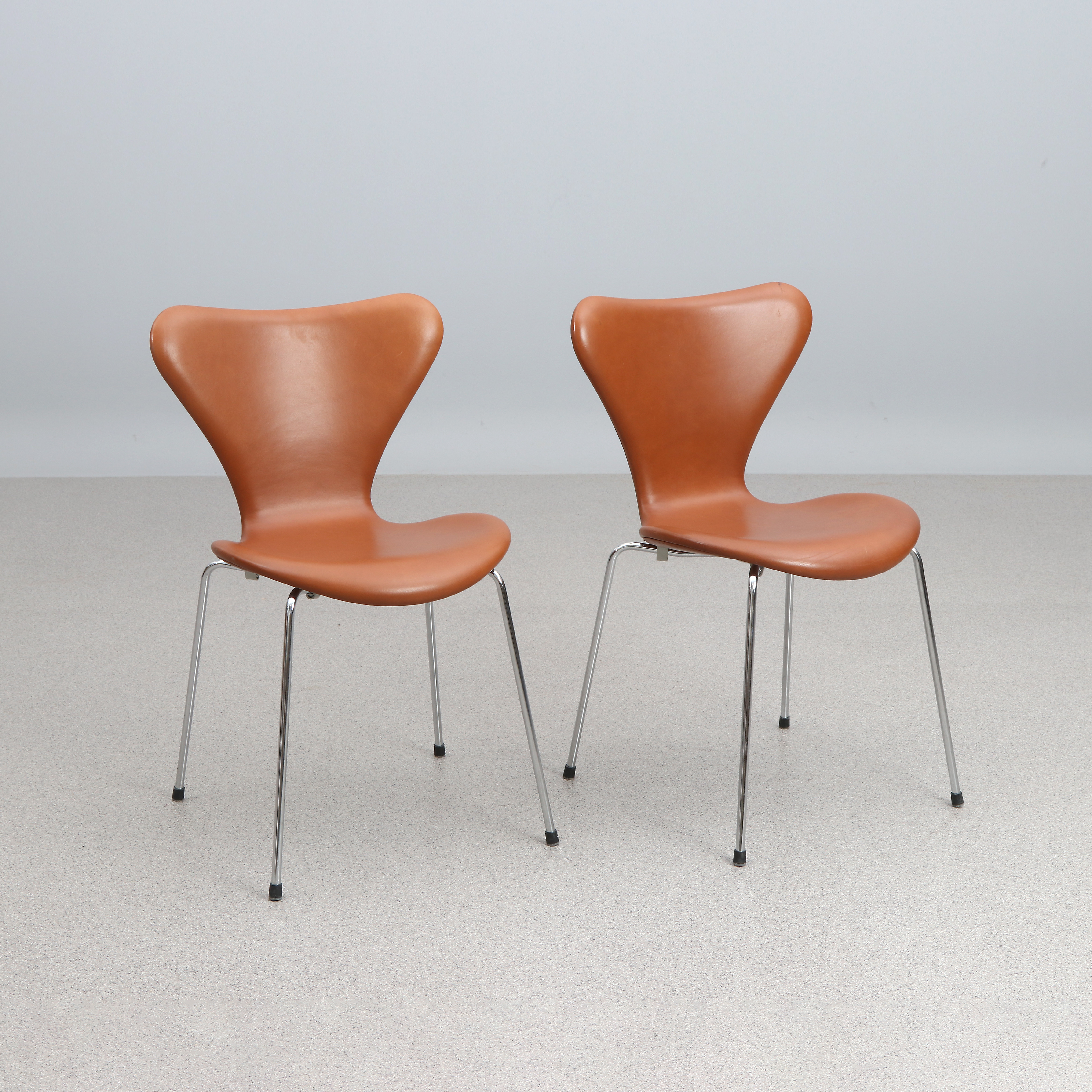 ARNE JACOBSEN. STOLAR, ETT PAR. Brun skinnklädsel, ben i förkromad metall. "Sjuan", Republic of Fritz Hansen, 2016. Etikettmärkta undertill.