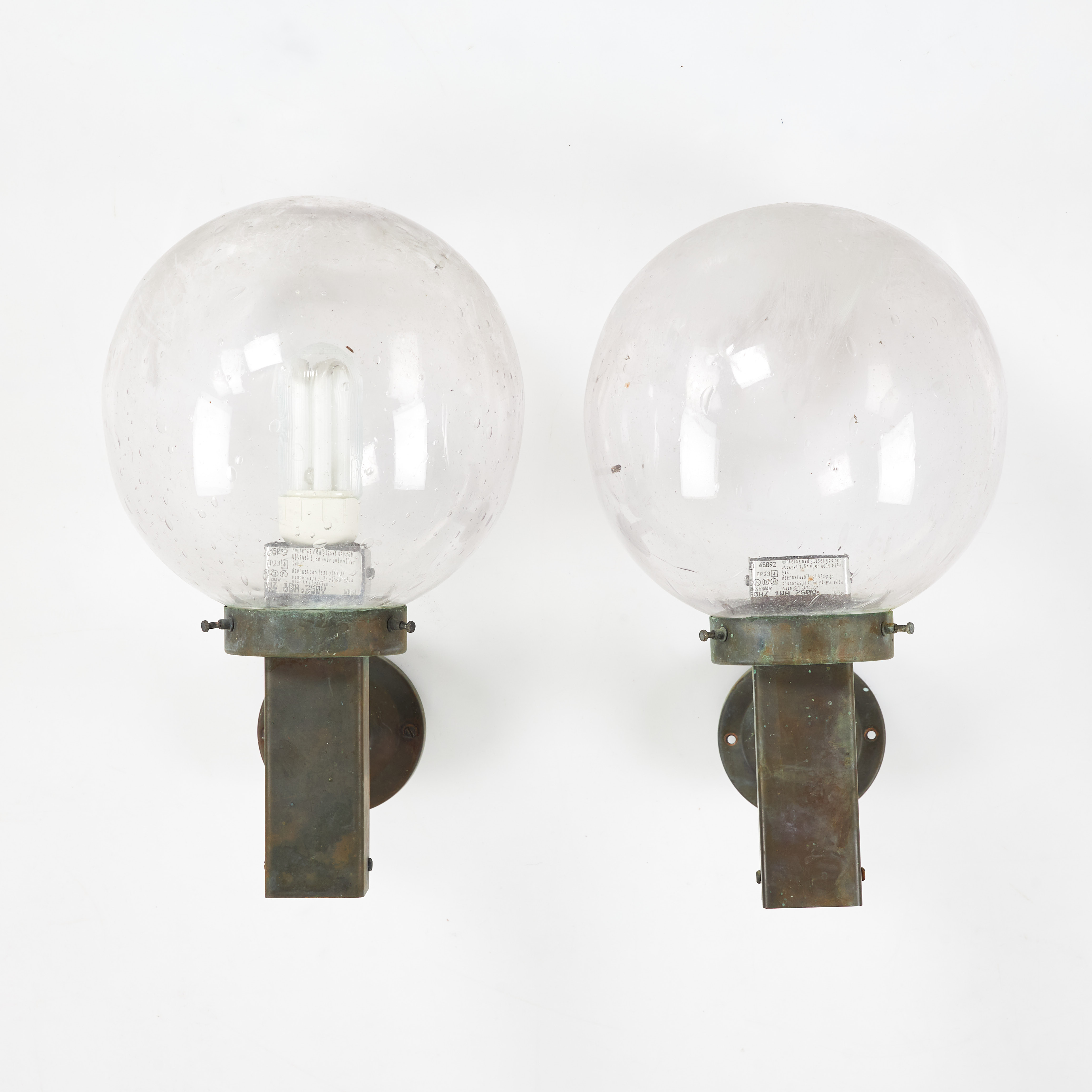 VÄGGLAMPOR, 1 par, patinerad metall, kupor i glas, stommen med bakomliggande eluttag, samtida tillverkning.