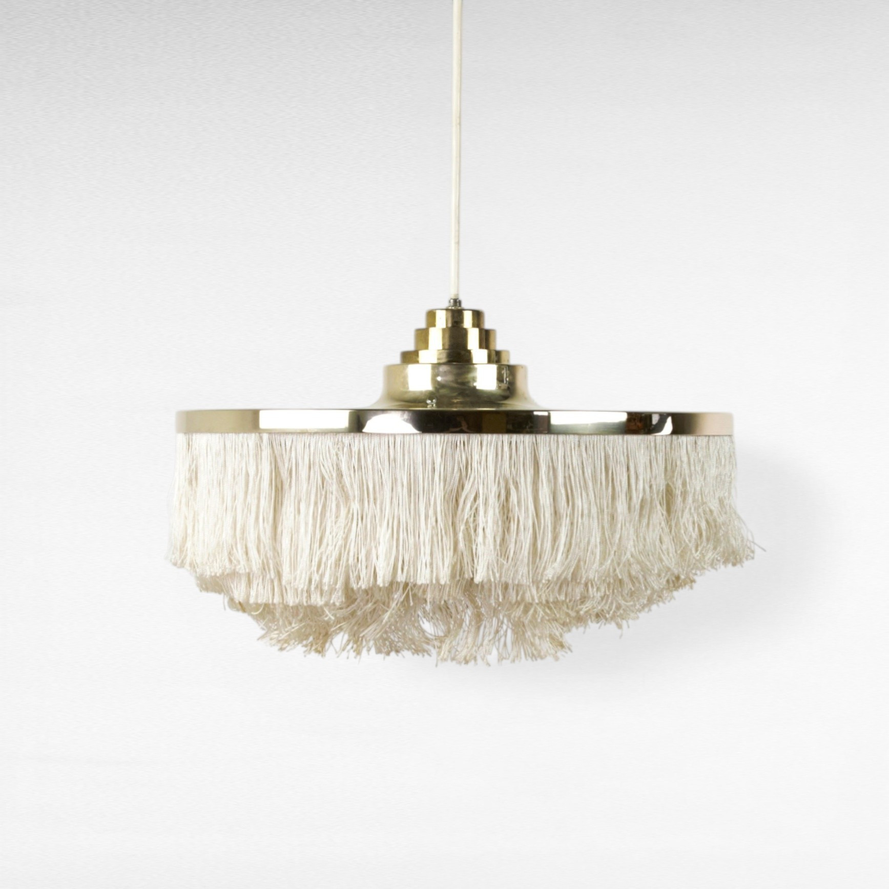 HANS-AGNE JAKOBSSON. Taklampa, stomme av mässing med ljusa fransar av silke, etikettmärkt Markaryd, 1960-tal.