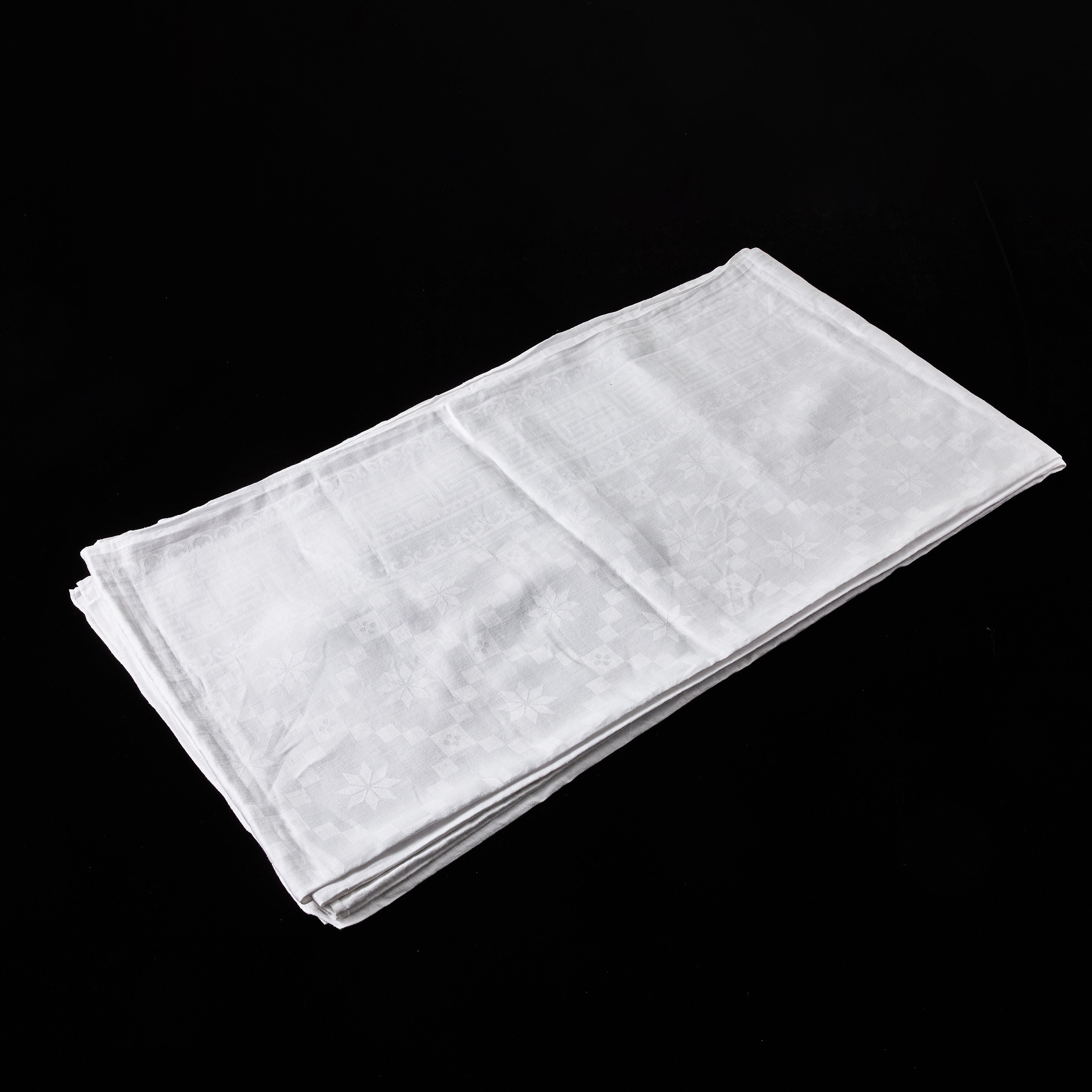 BORDSDUK, linnedamast, spegel med heltäckande, drälliknande mönster, bred bård av meanderslinga flankerad av tunnare bårder, broderat monogram (IF).