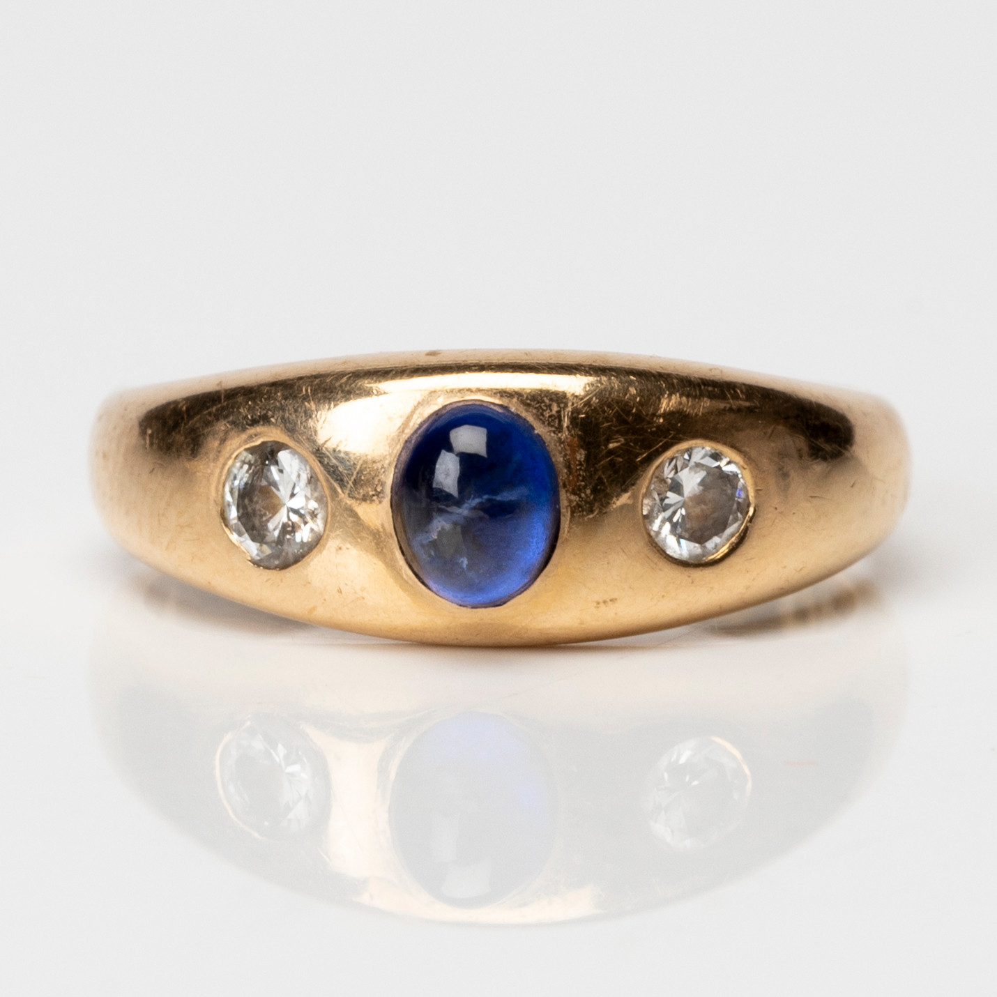 RING 18K guld, med 2 briljantslipade diamanter om totalt ca 0,24 ct samt 1 blå sten, Guldvaruhuset Aktiebolag, Stockholm, 1957.