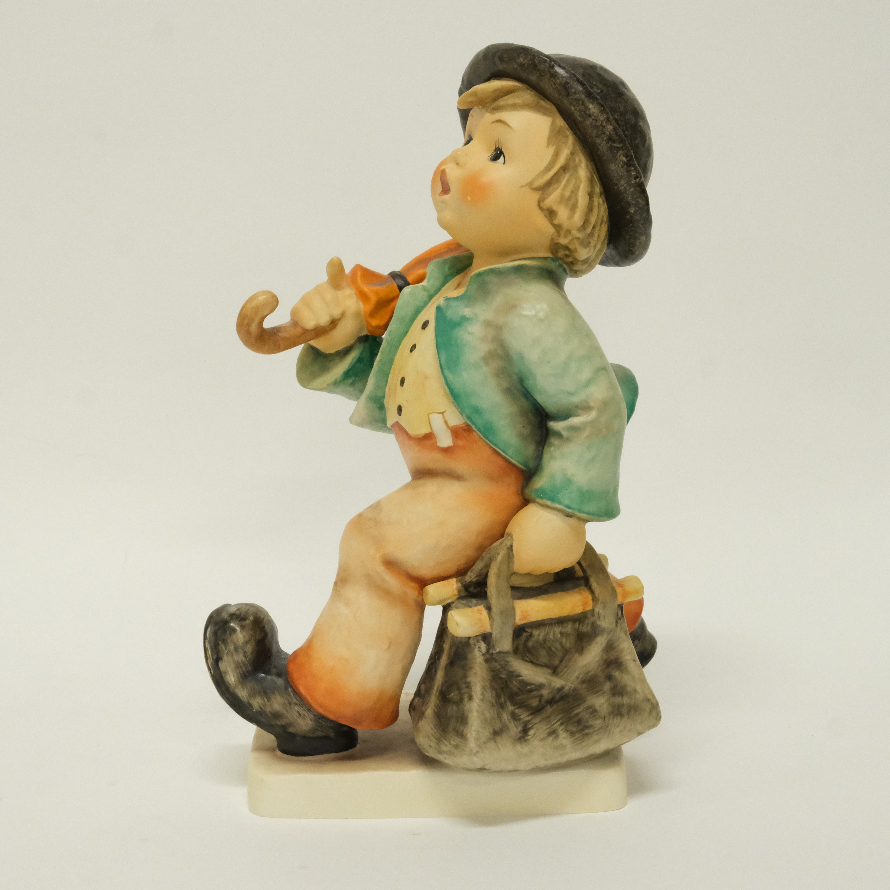 HUMMEL. FIGURIN. POJKE MED VÄSKA OCH PARAPLY. GOEBEL.