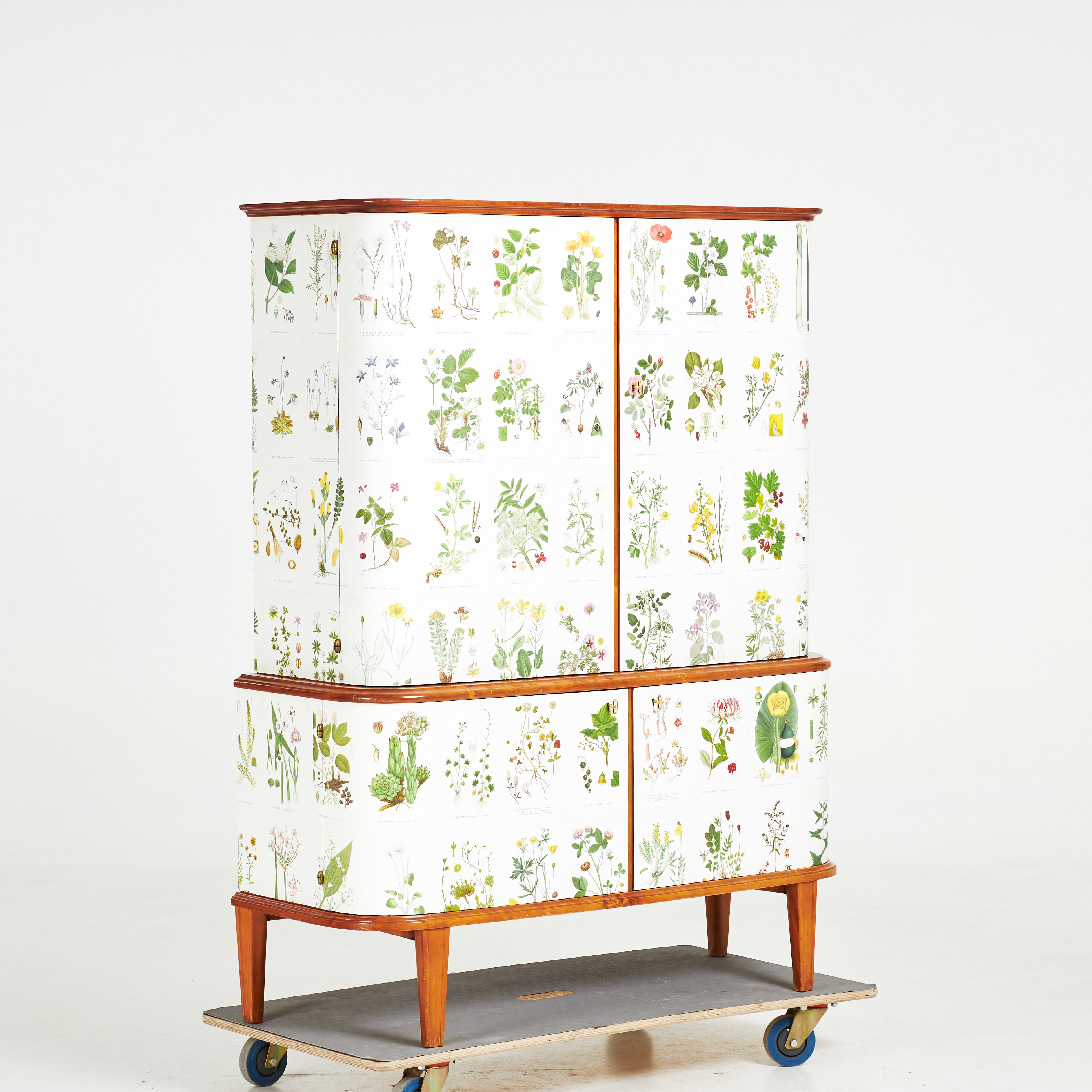SKÅP, 1940/50-tal, tapetserat med C.A.M Lindmans "Nordens Flora", invändigt med hyllplan samt lådor.