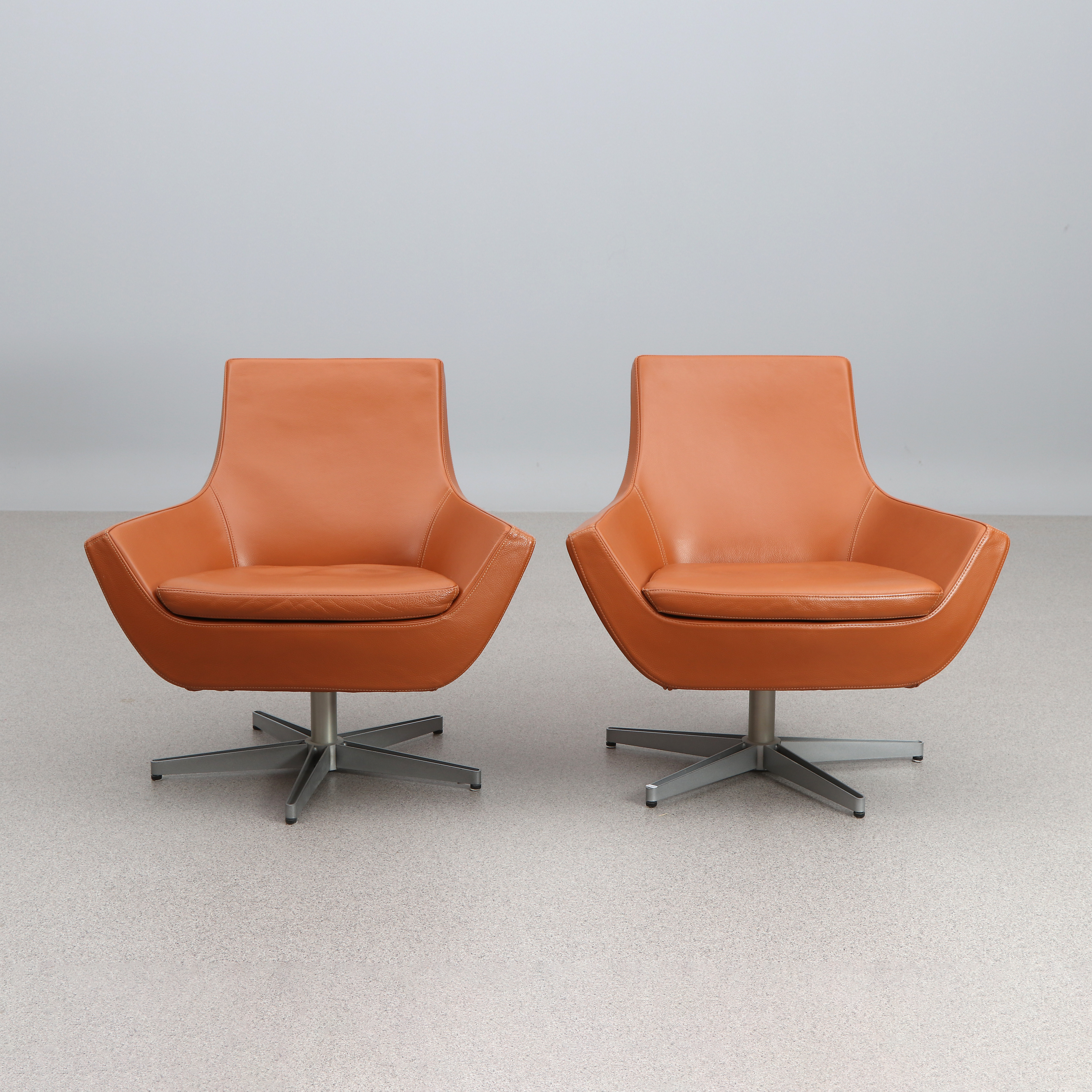 ROGER PERSSON. FÅTÖLJER, ETT PAR. Klädsel i brunt skinn, fötter i lackerad metall. "Happy Swing", Swedese.