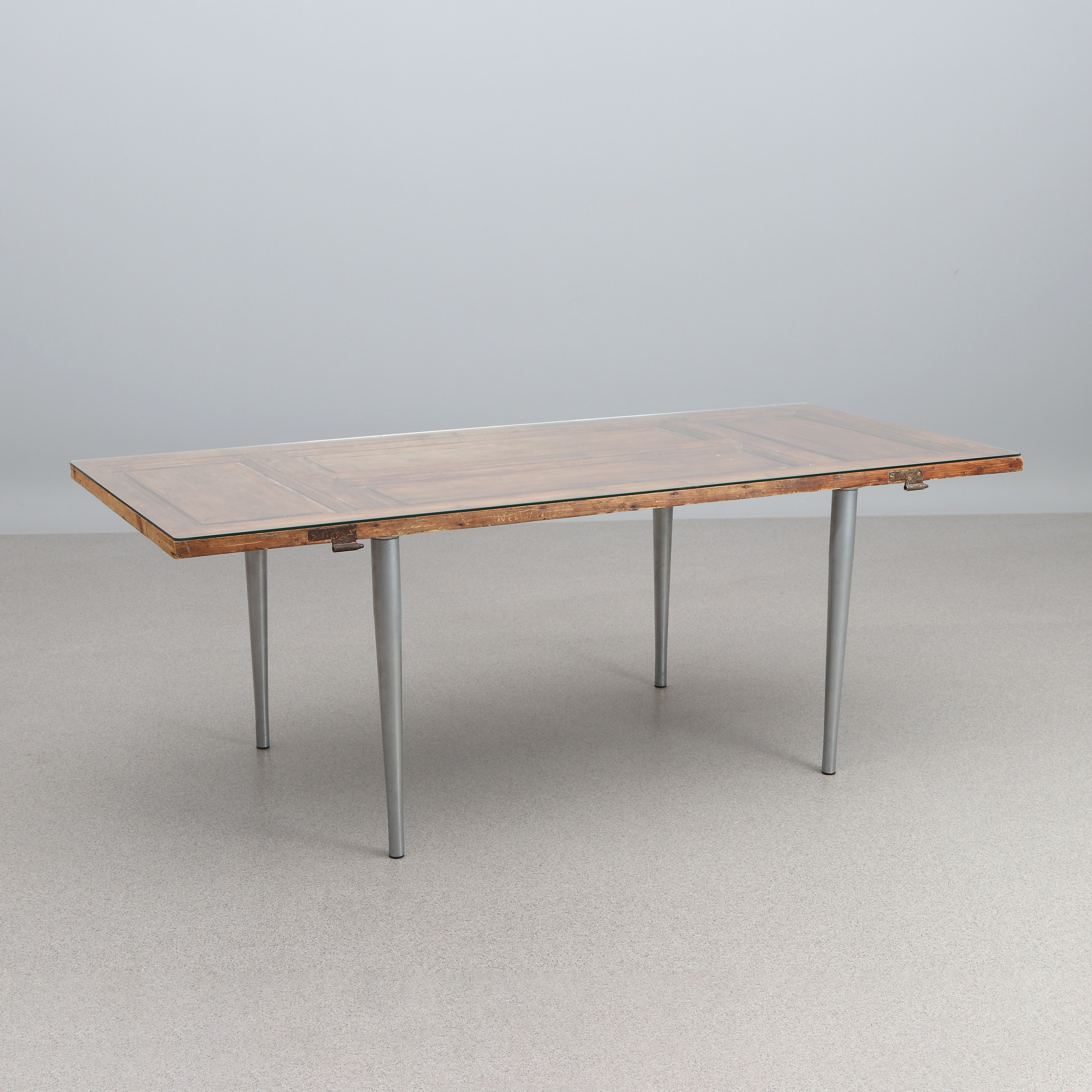 MATBORD. Äldre dörrblad i trä, med ben i lackerad metall samt glasskiva.