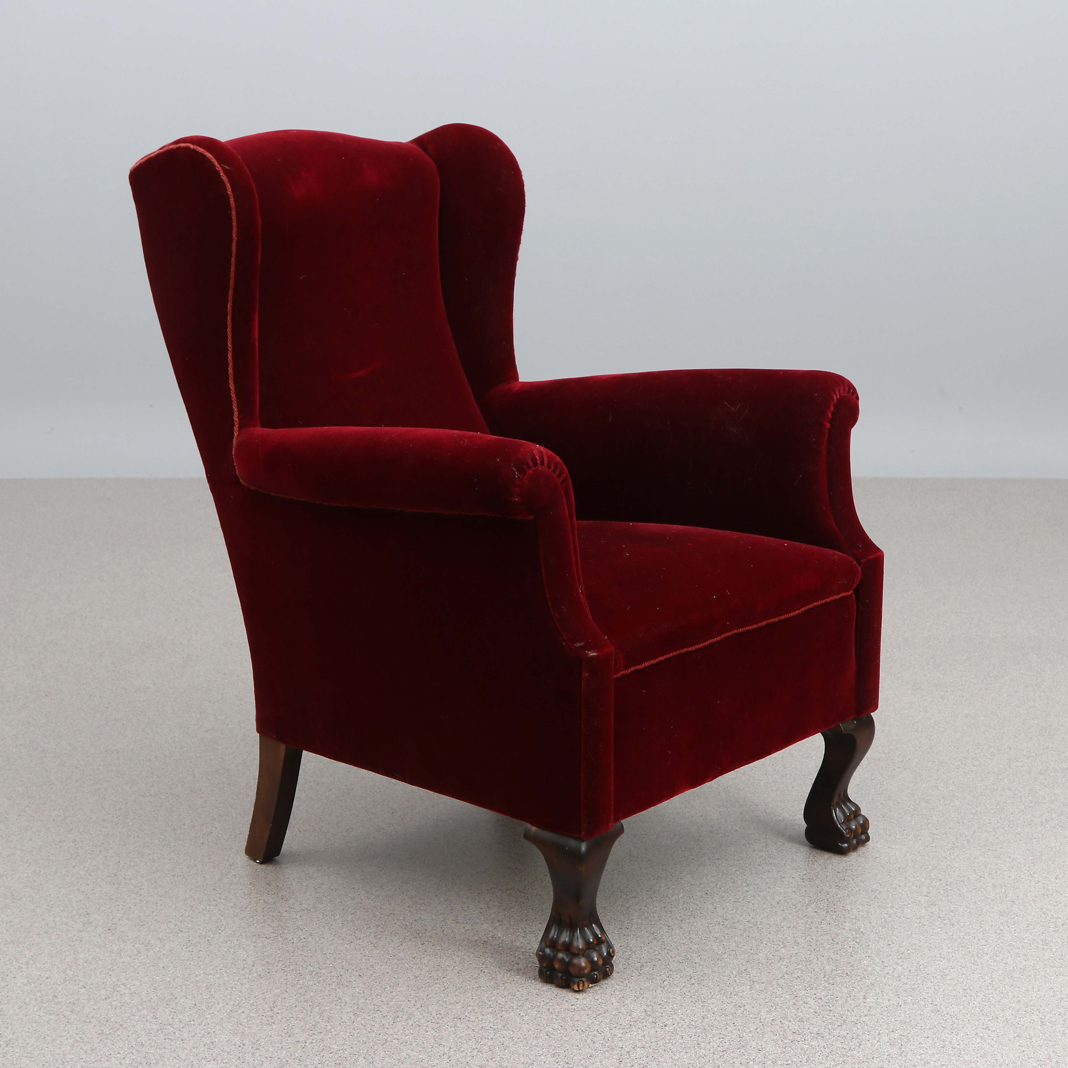 ÖRONLAPPSFÅTÖLJ. Röd plysch. 1900-talets första hälft.