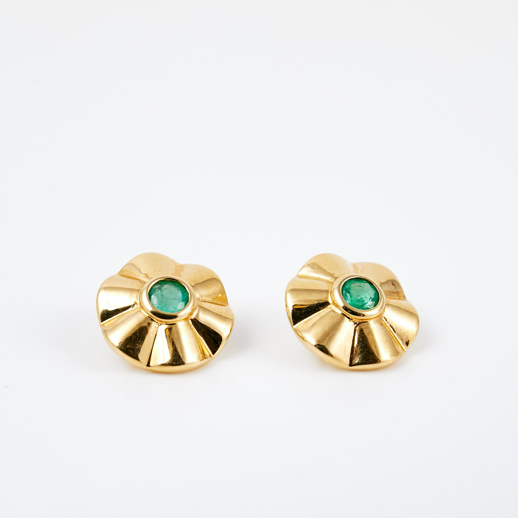 KNAPPAR, 1 par, 18 k guld, i form av stiliserad blomma, vardera med 1 fasettslipad smaragd.