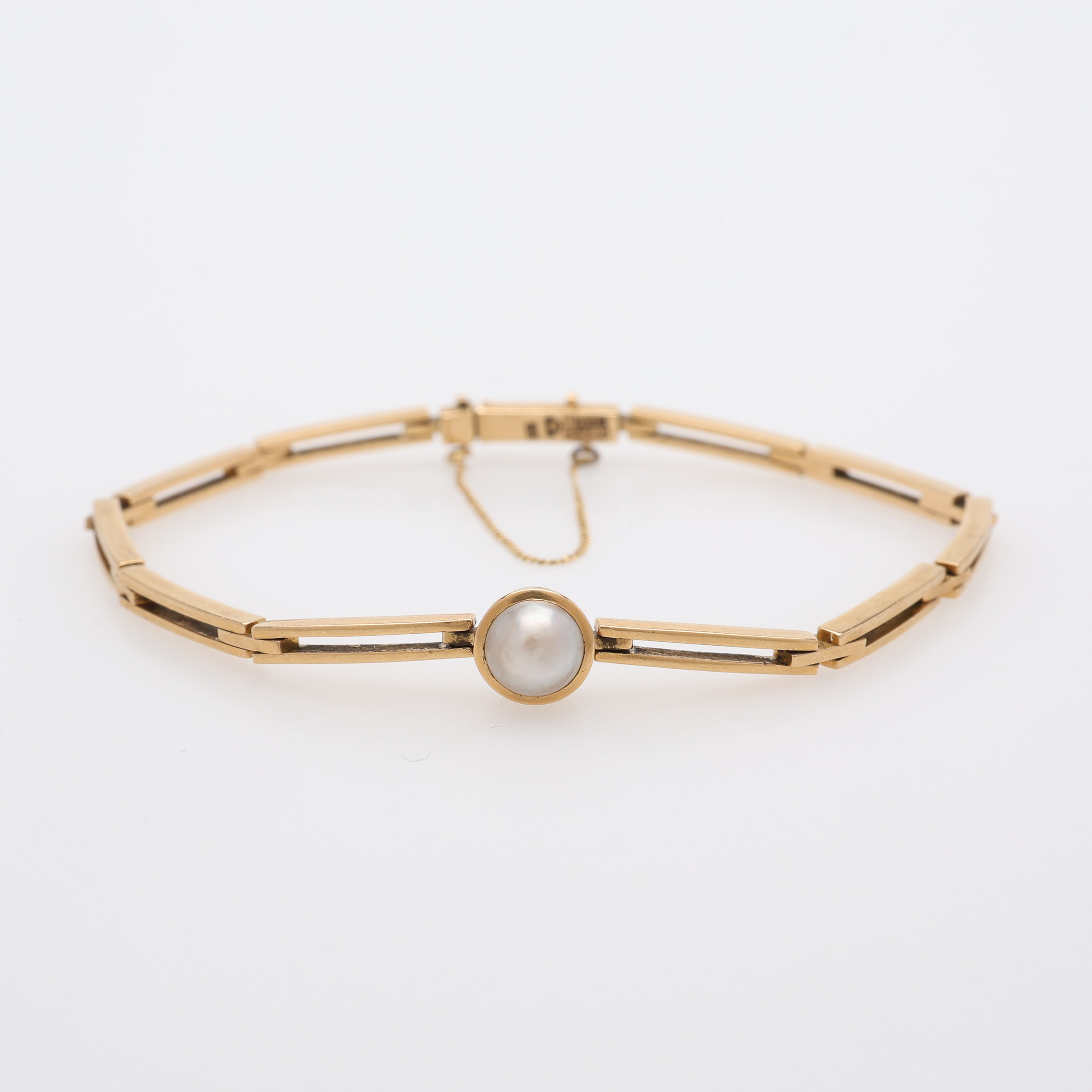 ARMBAND 18K MED EN ODLAD HALVPÄRLA.