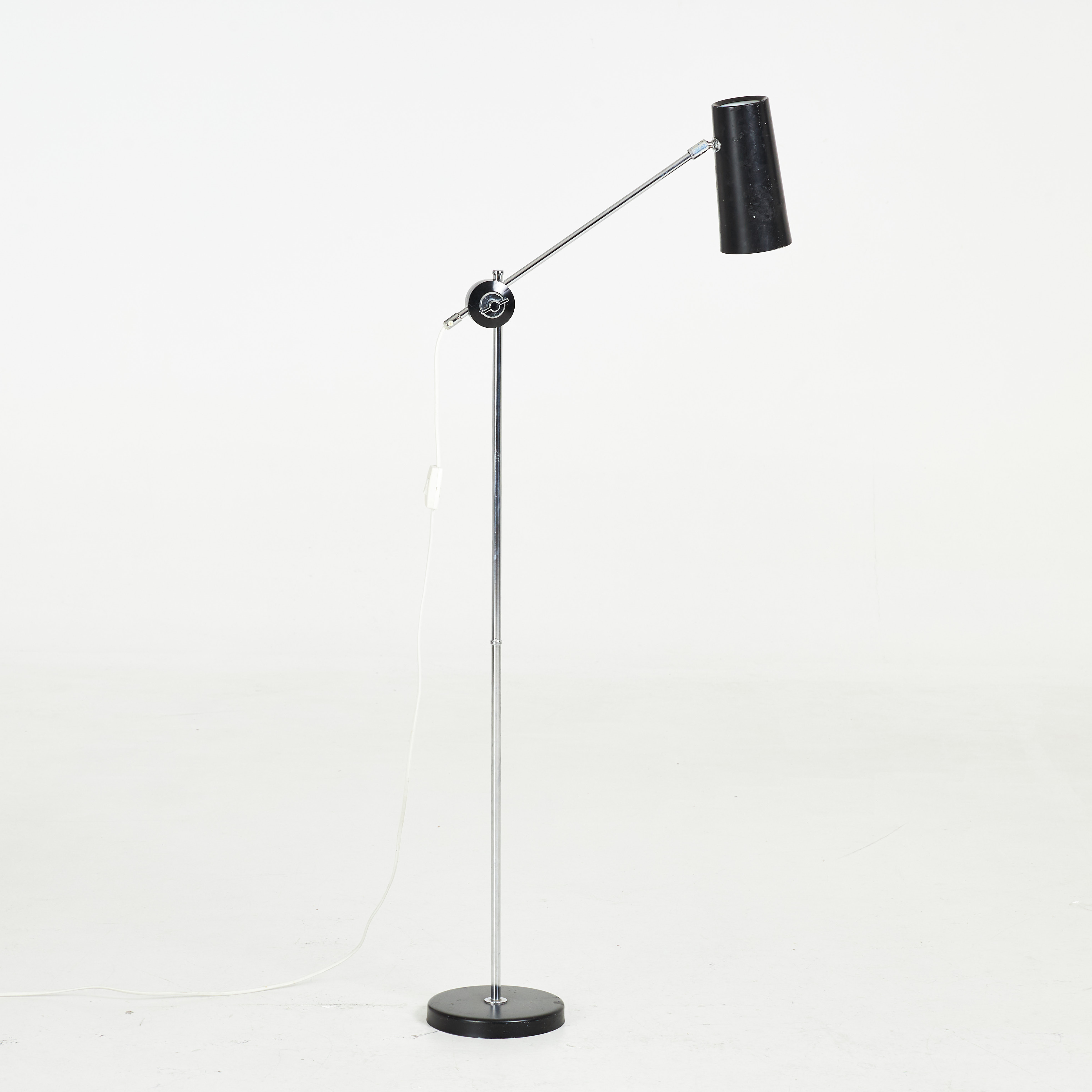 ANDERS PEHRSON. Golvlampa, stomme i kromad metall, skärm i svartlackerad plåt, ställbar ljusarm, etikettmärkt Ateljé Lyktan.
