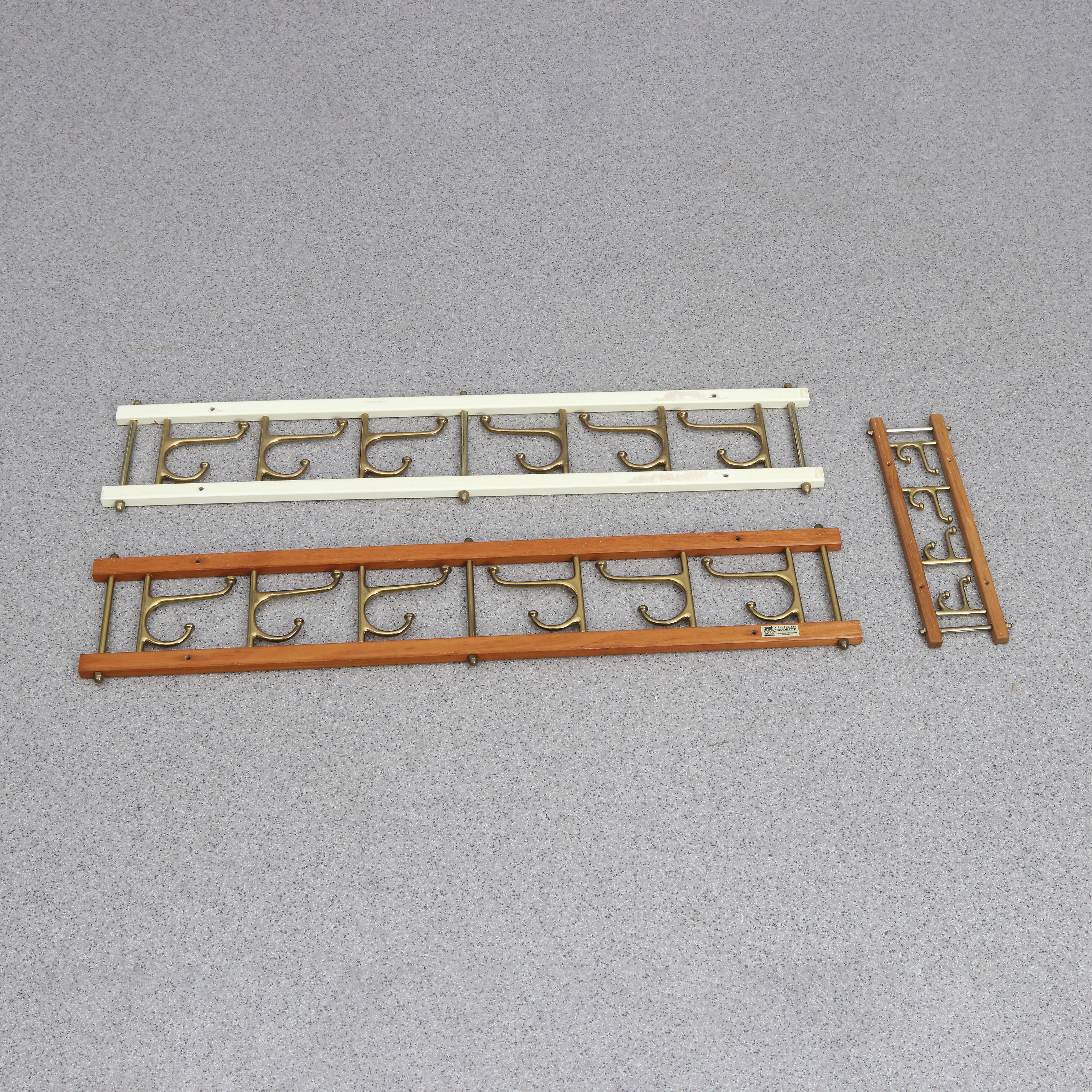 KLÄDHÄNGARE, TRE ST. Teak resp. lackerad metall samt mässing. En märkt klädhängaren Dekorativ, Anderstorp.