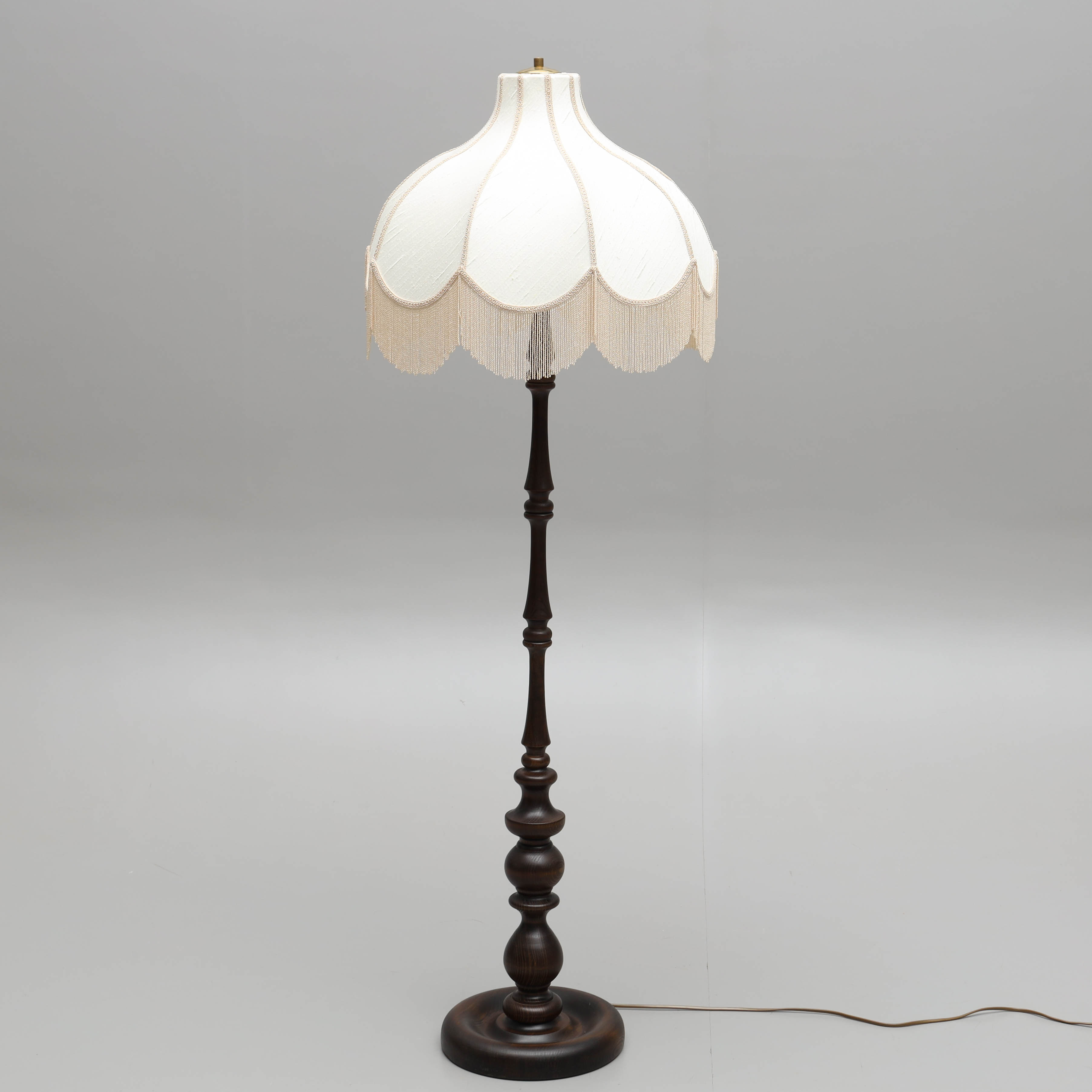 GOLVLAMPA, svarvad fot i trä, skärm i textil med fransar, Markslöjd, 1900-tal.