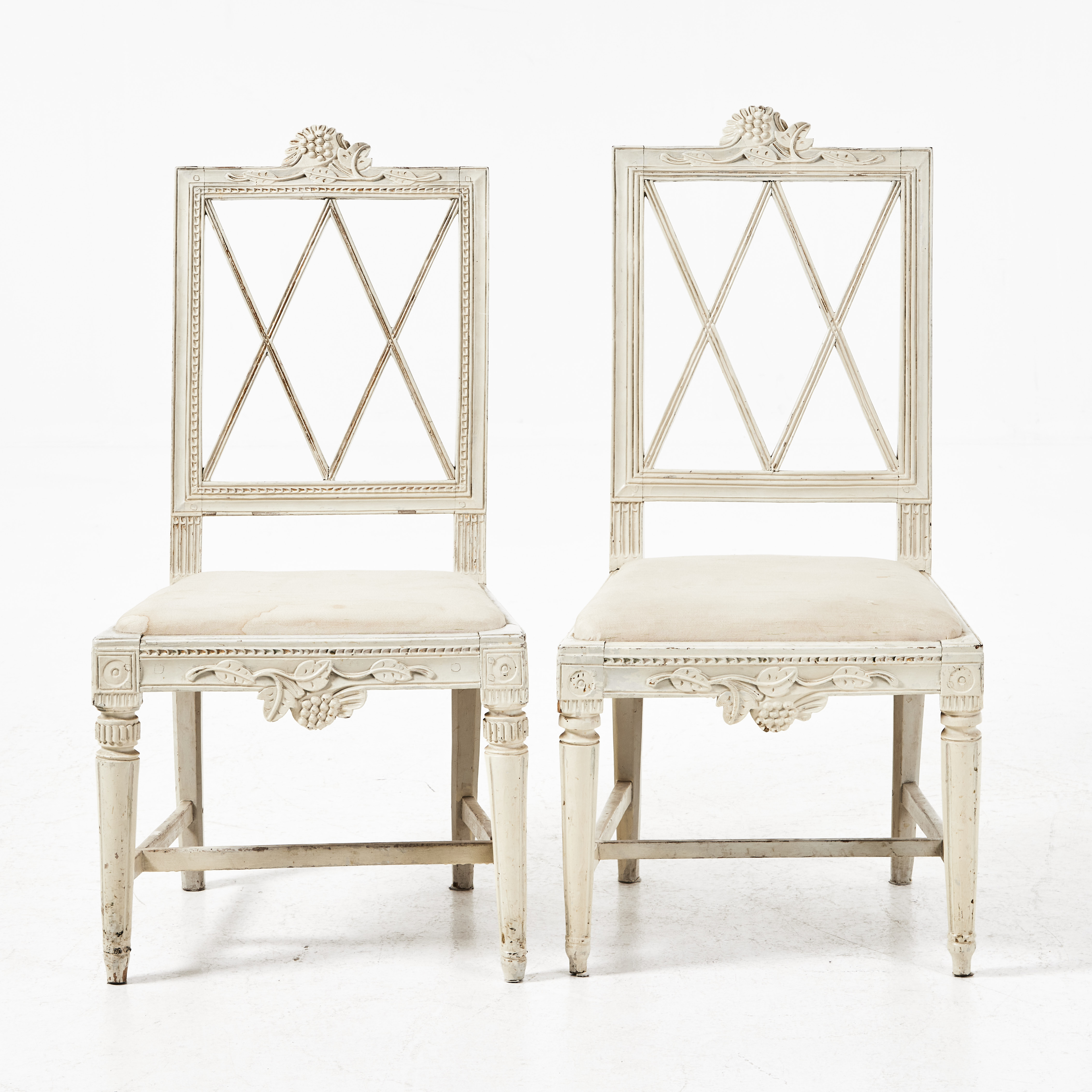 STOLAR, 2 stycken snarlika, gustavianska, 1700-talets slut, vitmålade med skulpterad dekor. Löstagbara textilklädda sitsar.