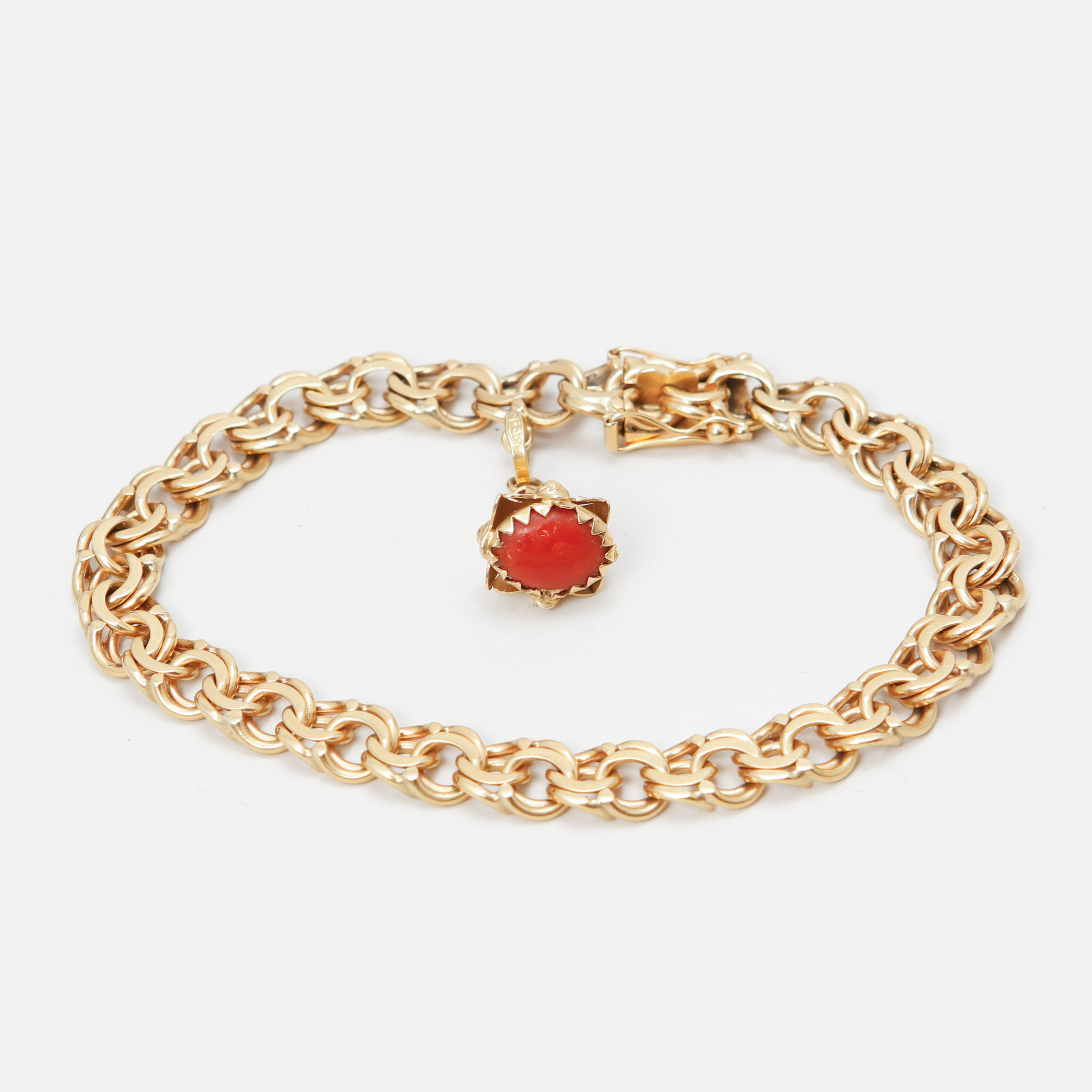 ARMLÄNK med en berlock, 18k guld och korall. Vikt ca 24,3 g.