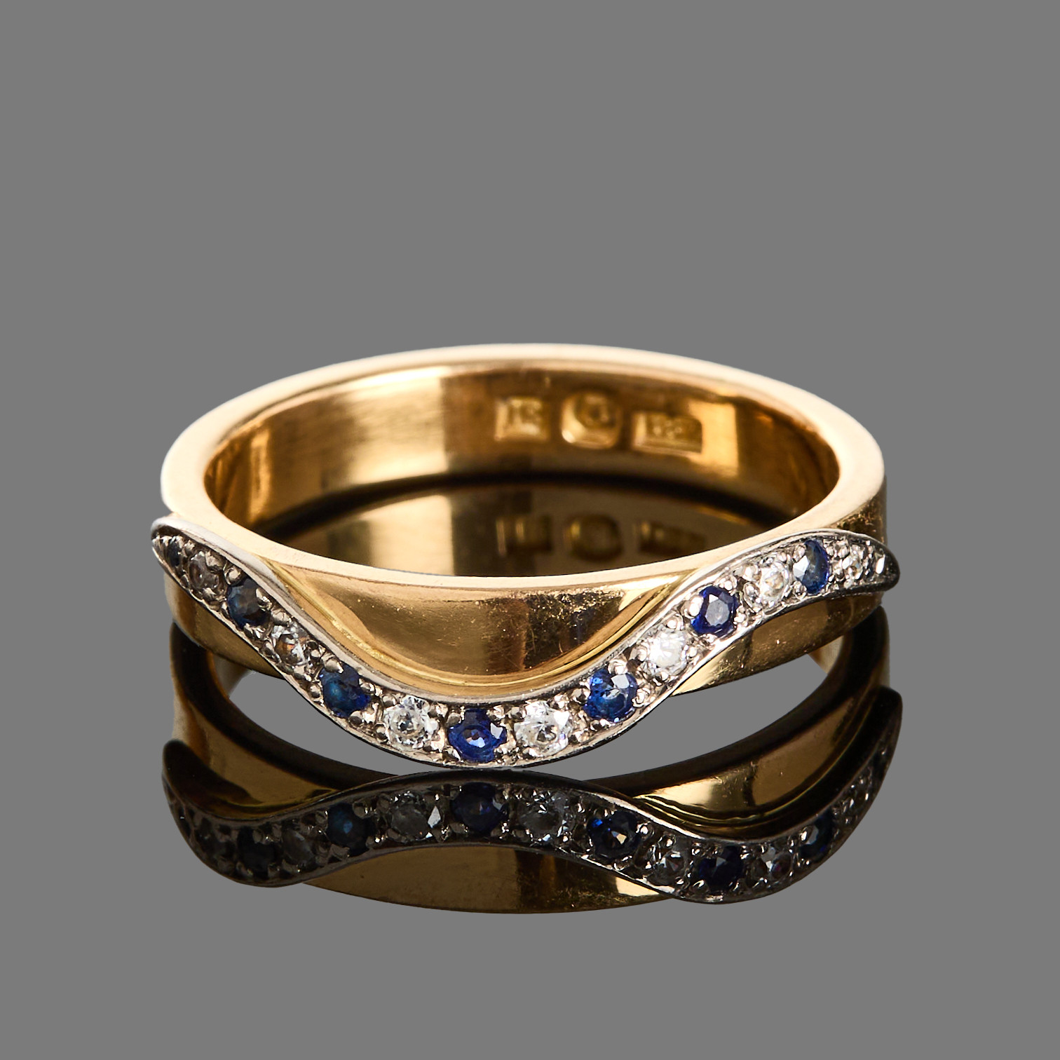 RING, 18k guld dekorarat med ett band av vitguld med blå safirer och glas.
